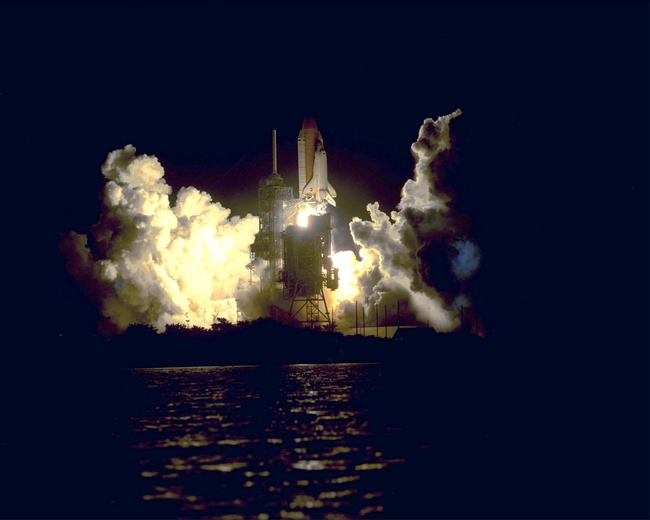 KENNEDY SPACE CENTER, Fla. -- Billows of smoke and steam surround Space Shuttle Discovery as it lifts off from Launch Pad 39A on mission STS-92 to the International Space Station. The perfect on-time liftoff occurred at 7:17 p.m. EDT, sending a crew of seven on the 100th launch in the history of the Shuttle program. Discovery carries a payload that includes the Integrated Truss Structure Z-1, first of 10 trusses that will form the backbone of the Space Station, and the third Pressurized Mating Adapter that will provide a Shuttle docking port for solar array installation on the sixth Station flight and Lab installation on the seventh Station flight. Discovery’s landing is expected Oct. 22 at 2:10 p.m. EDT