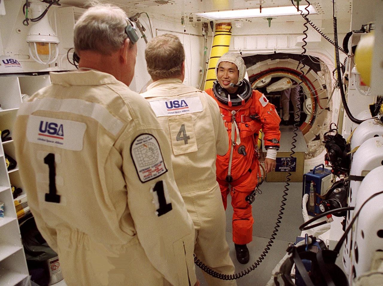 STS-92 Mission Specialist Koichi Wakata of Japan gets a final check of his launch and entry suit in the White Room before entering Discovery. The White Room is an environmentally controlled area at the end of the Orbiter Access Arm that provides entry to the orbiter as well as emergency egress if needed. The arm remains in the extended position until 7 minutes 24 seconds before launch. Wakata and the rest of the crew are making the fifth flight to the International Space Station for construction. Discovery carries a payload that includes the Integrated Truss Structure Z-1, first of 10 trusses that will form the backbone of the Space Station, and the third Pressurized Mating Adapter that will provide a Shuttle docking port for solar array installation on the sixth Station flight and Lab installation on the seventh Station flight. The mission includes four spacewalks for the construction activities. Discovery’s landing is expected Oct. 22 at 2:10 p.m. EDT