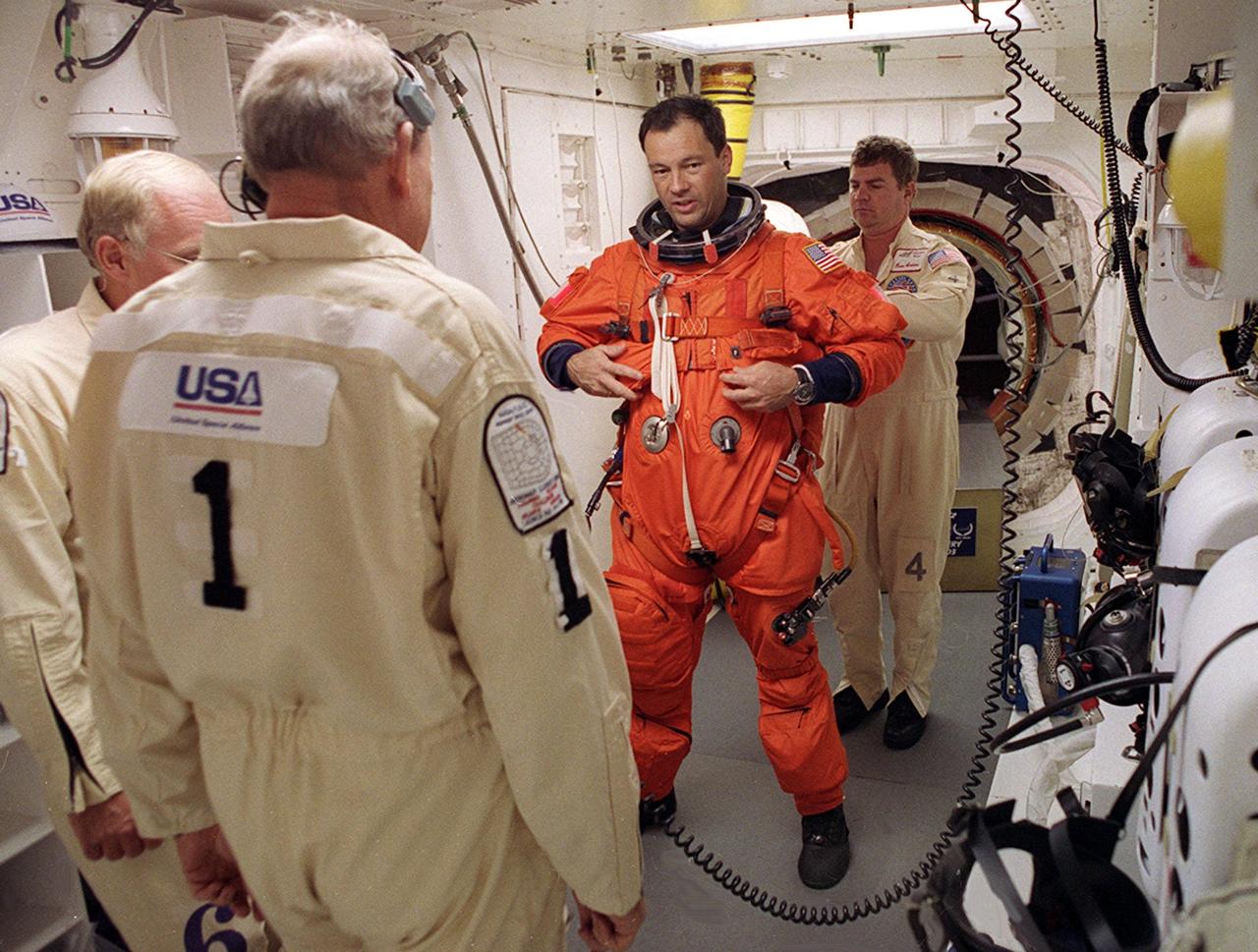 STS-92 Mission Specialist Michael E. Lopez-Alegria gets a final check of his launch and entry suit in the White Room before entering Discovery. The White Room is an environmentally controlled area at the end of the Orbiter Access Arm that provides entry to the orbiter as well as emergency egress if needed. The arm remains in the extended position until 7 minutes 24 seconds before launch. Lopez-Alegria and the rest of the crew are undertaking the fifth flight to the International Space Station for construction. Discovery carries a payload that includes the Integrated Truss Structure Z-1, first of 10 trusses that will form the backbone of the Space Station, and the third Pressurized Mating Adapter that will provide a Shuttle docking port for solar array installation on the sixth Station flight and Lab installation on the seventh Station flight. The mission includes four spacewalks for the construction activities. Discovery’s landing is expected Oct. 22 at 2:10 p.m. EDT
