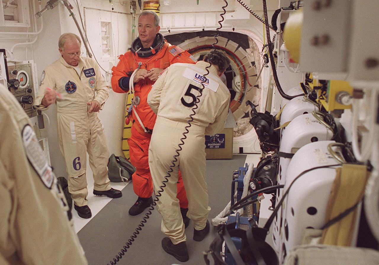STS-92 Commander Brian Duffy is helped with final suit check in the White Room before entering Discovery. The White Room is an environmentally controlled area at the end of the Orbiter Access Arm that provides entry to the orbiter as well as emergency egress if needed. The arm remains in the extended position until 7 minutes 24 seconds before launch. Duffy and the rest of the crew are undertaking the fifth flight to the International Space Station for construction. Discovery carries a payload that includes the Integrated Truss Structure Z-1, first of 10 trusses that will form the backbone of the Space Station, and the third Pressurized Mating Adapter that will provide a Shuttle docking port for solar array installation on the sixth Station flight and Lab installation on the seventh Station flight. The mission includes four spacewalks for the construction activities. Discovery’s landing is expected Oct. 22 at 2:10 p.m. EDT