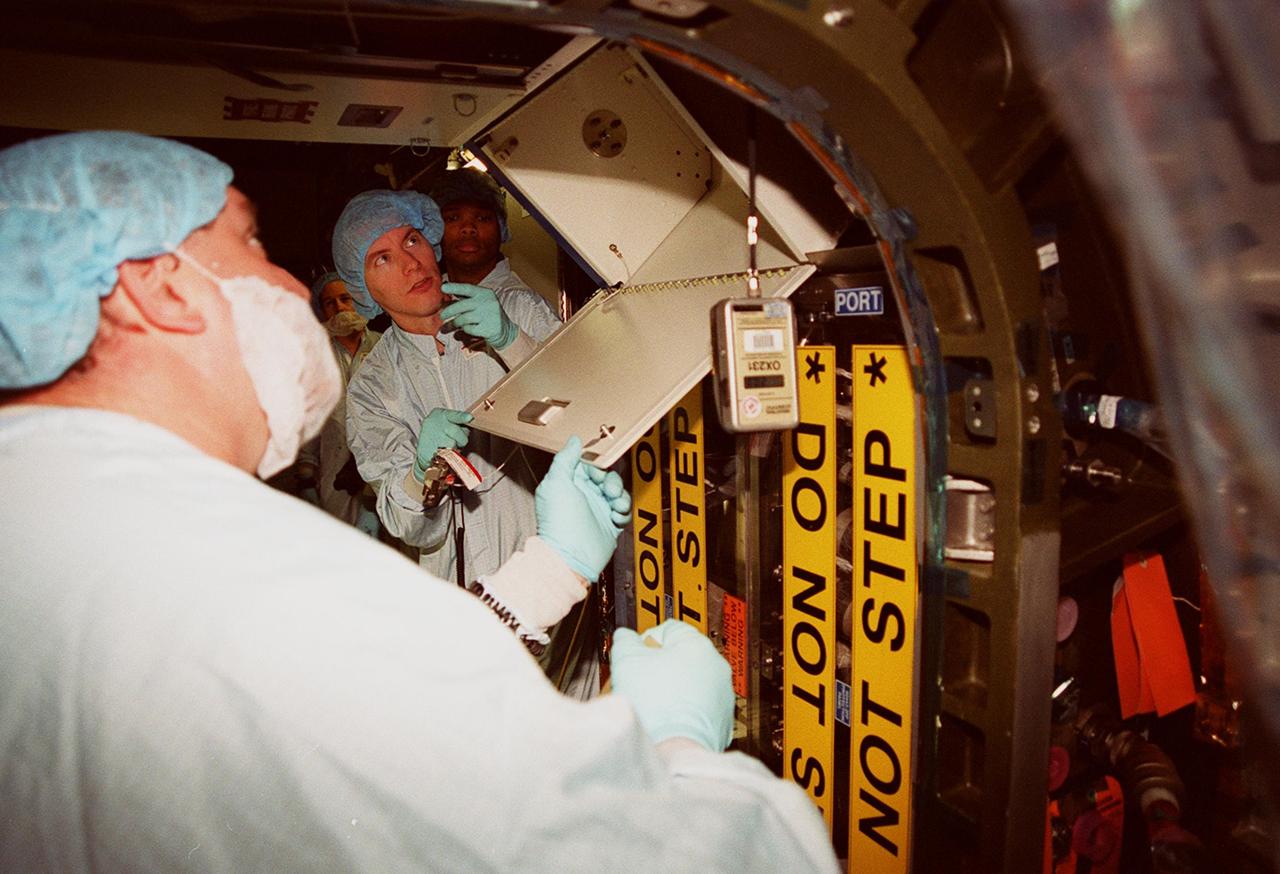 In the Space Station Processing Facility, members of the STS-98 crew check out components inside the U.S. Lab, Destiny, under the watchful eye of trainers. The crew comprises Commander Ken Cockrell, Pilot Mark Polansky and Mission Specialists Robert Curbeam, Thomas Jones and Marsha Ivins. They are taking part in Crew Equipment Interface Test activities, becoming familiar with equipment they will be handling during the mission. The mission will be transporting the Lab to the International Space Station with five system racks already installed inside of the module. With delivery of electronics in the lab, electrically powered attitude control for Control Moment Gyroscopes will be activated. The STS-98 launch is scheduled for Jan. 18, 2001