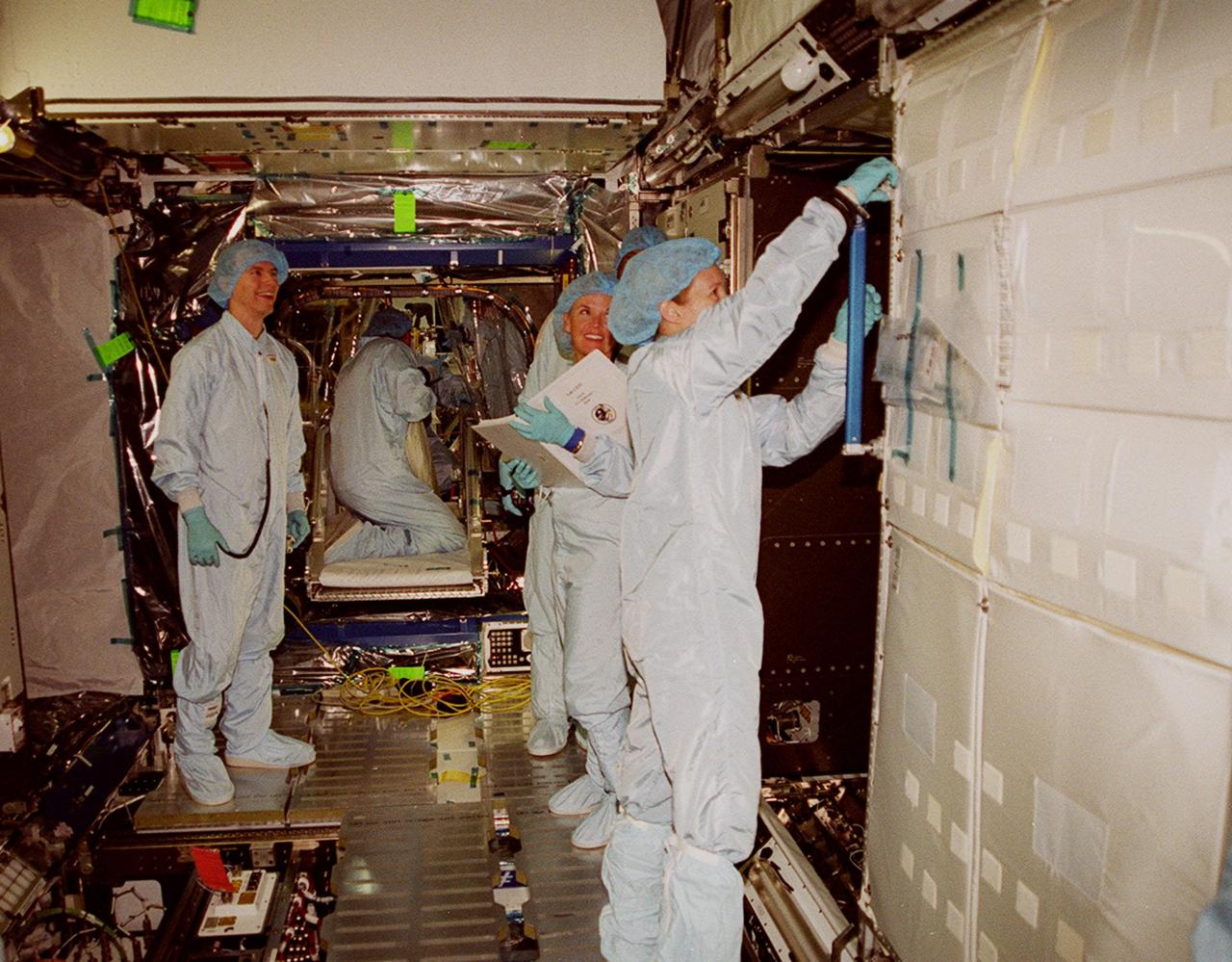 In the Space Station Processing Facility, STS-98 Mission Specialist Marsha Ivins maneuvers a part of the U.S. Lab, Destiny. The crew is checking out equipment inside the lab as part of Crew Equipment Interface Test activities, becoming familiar with equipment it will be handling during the mission. Others in the crew are Commander Ken Cockrell, Pilot Mark Polansky and Mission Specialists Robert Curbeam and Thomas Jones. The mission will be transporting the Lab to the International Space Station with five system racks already installed inside of the module. With delivery of electronics in the lab, electrically powered attitude control for Control Moment Gyroscopes will be activated. The STS-98 launch is scheduled for Jan. 18, 2001