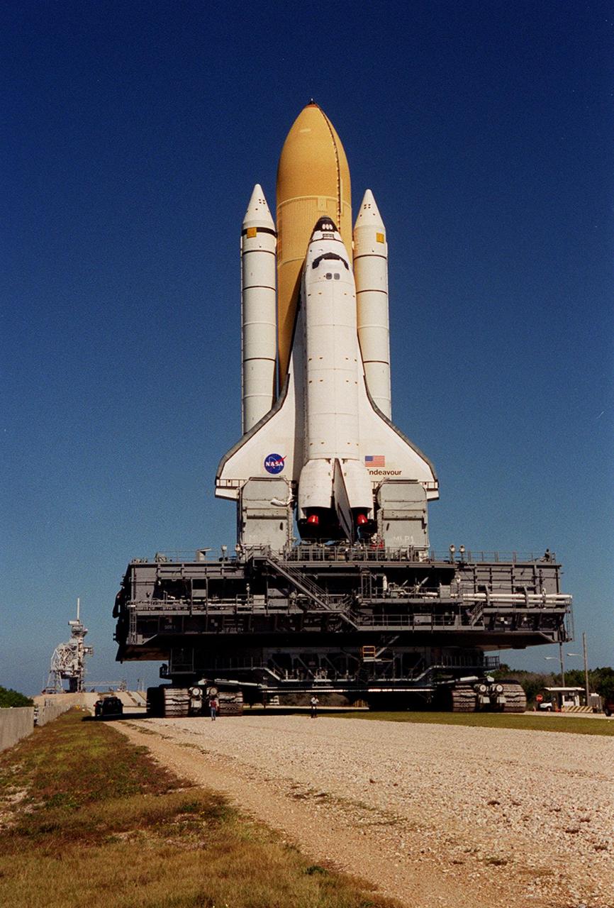 KENNEDY SPACE CENTER, FLA. -- Space Shuttle Endeavour approaches the incline to Launch Pad 39B, where the Rotating and Fixed Service Structures can be seen in the background to the left. Moments after this photo was taken, workers noticed one of the crawler-transporter cleats was cracked and rollout was delayed until the cleat could be replaced. The Space Shuttle was hard down on the pad several hours later. Endeavour is scheduled to be launched Nov. 30 at 10:01 p.m. EST on mission STS-97, the sixth construction flight to the International Space Station. Its payload includes the P6 Integrated Truss Structure and a photovoltaic (PV) module, with giant solar arrays that will provide power to the Station. The mission includes two spacewalks to complete the solar array connections