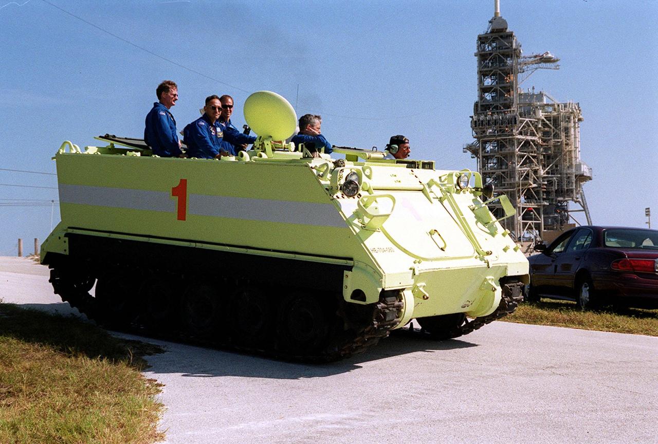During Terminal Countdown Demonstration Test (TCDT) activities, the STS-97 crew ride as passengers in the M-113 while trainer Capt. George Hoggard (at right) drives away from Launch Pad 39B. Seen left to right are Mission Specialists Joe Tanner and Carlos Noriega; Pilot Mike Bloomfield; and Mission Specialist Marc Garneau, who is with the Canadian Space Agency. Learning to drive the armored vehicle is part of emergency egress training during TCDT. The tracked vehicle could be used by the crew in the event of an emergency at the pad during which the crew must make a quick exit from the area. The TCDT also provides simulated countdown exercises and opportunities to inspect the mission payloads in the orbiter’s payload bay. Mission STS-97is the sixth construction flight to the International Space Station. Its payload includes the P6 Integrated Truss Structure and a photovoltaic (PV) module, with giant solar arrays that will provide power to the Station. The mission includes two spacewalks to complete the solar array connections. STS-97 is scheduled to launch Nov. 30 at 10:05 p.m. EST