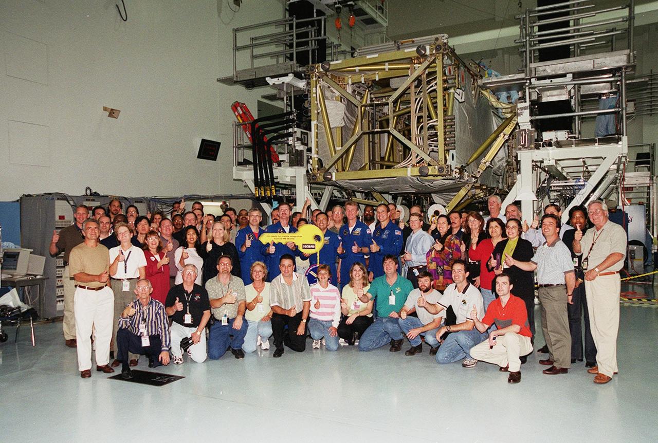 Workers in the Space Station Processing Facility gather with the crew of mission STS-97, who are holding the symbolic key representing the turnover of the P6 Integrated Truss Structure, part of the payload on their mission. During the ceremony the P6 truss segment was transferred from International Space Station ground operations to the NASA shuttle integration team. Commander Brent Jett (second from right) received the key in the ceremony. Standing with him are (left to right) Mission Specialists Marc Garneau, Joe Tanner and Carlos Noriega, at left; and Pilot Mike Bloomfield, at right. Mission STS-97is the sixth construction flight to the International Space Station. Its payload includes a photovoltaic (PV) module, with giant solar arrays that will provide power to the Station. The mission involves two spacewalks to complete the solar array connections. STS-97 is scheduled to launch Nov. 30 at 10:05 p.m. EST