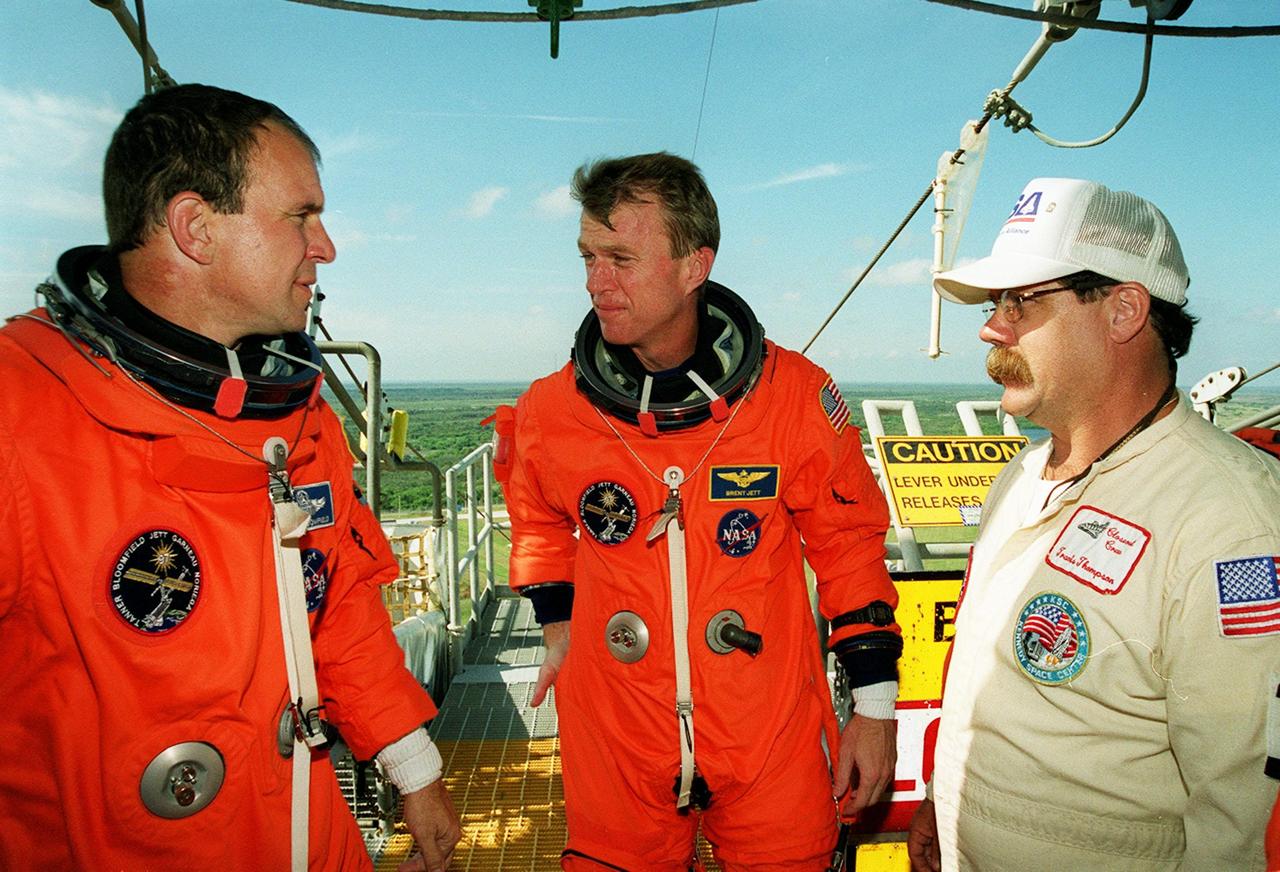 During emergency egress practice at Launch Pad 39B, STS-97 Pilot Mike Bloomfield (left) and Commander Brent Jett (center) discuss their activities with Closeout Crew member Travis Thompson (right). The practice is part of Terminal Countdown Demonstration Test (TCDT) activities that also include a simulated launch countdown and opportunities to inspect the mission payloads in the orbiter’s payload bay. Mission STS-97is the sixth construction flight to the International Space Station. Its payload includes the P6 Integrated Truss Structure and a photovoltaic (PV) module, with giant solar arrays that will provide power to the Station. The mission includes two spacewalks to complete the solar array connections. STS-97 is scheduled to launch Nov. 30 at 10:05 p.m. EST