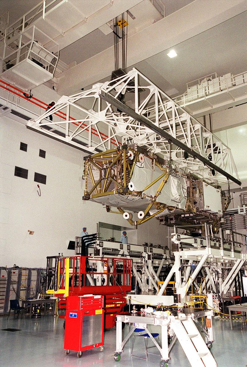 In the Space Station Processing Facility, an overhead crane lifts the P6 integrated truss segment from a workstand to place it in the payload transport canister for transfer to Launch Pad 39B. There it will be placed in Endeavour’s payload bay for launch on mission STS-97. The P6 comprises Solar Array Wing-3 and the Integrated Electronic Assembly, to be installed on the International Space Station. The Station’s electrical power system will use eight photovoltaic solar arrays, each 112 feet long by 39 feet wide, to convert sunlight to electricity. The solar arrays are mounted on a “blanket” that can be folded like an accordion for delivery. Once in orbit, astronauts will deploy the blankets to their full size. Gimbals will be used to rotate the arrays so that they will face the Sun to provide maximum power to the Space Station. Launch is scheduled Nov. 30 at 10:06 p.m. EST