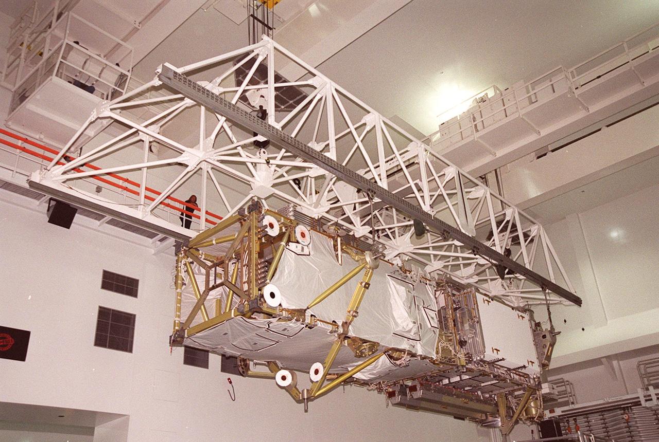 In the Space Station Processing Facility, an overhead crane moves the P6 integrated truss segment to a payload transport canister for transfer to Launch Pad 39B. There it will be placed in Endeavour’s payload bay for launch on mission STS-97. The P6 comprises Solar Array Wing-3 and the Integrated Electronic Assembly, to be installed on the International Space Station. The Station’s electrical power system will use eight photovoltaic solar arrays, each 112 feet long by 39 feet wide, to convert sunlight to electricity. The solar arrays are mounted on a “blanket” that can be folded like an accordion for delivery. Once in orbit, astronauts will deploy the blankets to their full size. Gimbals will be used to rotate the arrays so that they will face the Sun to provide maximum power to the Space Station. Launch is scheduled Nov. 30 at 10:06 p.m. EST
