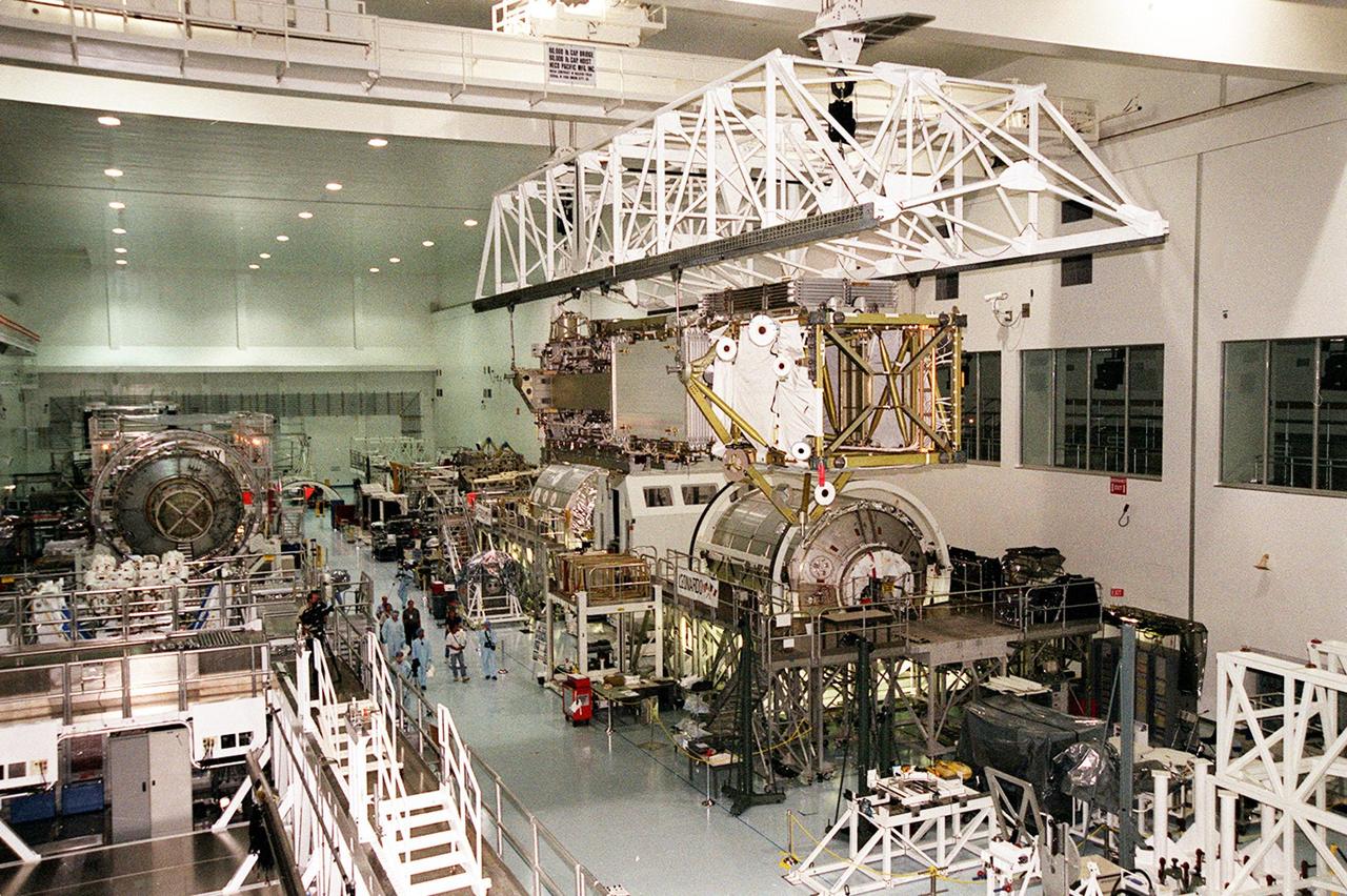 Carried by an overhead crane, the P6 integrated truss segment travels the length of the Space Station Processing Facility toward a payload transport canister that will transfer it to Launch Pad 39B. At the pad, the Space Station element will be placed in Endeavour’s payload bay for launch on mission STS-97. The P6 comprises Solar Array Wing-3 and the Integrated Electronic Assembly, to be installed on the Space Station. The Station’s electrical power system will use eight photovoltaic solar arrays, each 112 feet long by 39 feet wide, to convert sunlight to electricity. The solar arrays are mounted on a “blanket” that can be folded like an accordion for delivery. Once in orbit, astronauts will deploy the blankets to their full size. Gimbals will be used to rotate the arrays so that they will face the Sun to provide maximum power to the Space Station. The STS-97 launch is scheduled Nov. 30 at 10:06 p.m. EST