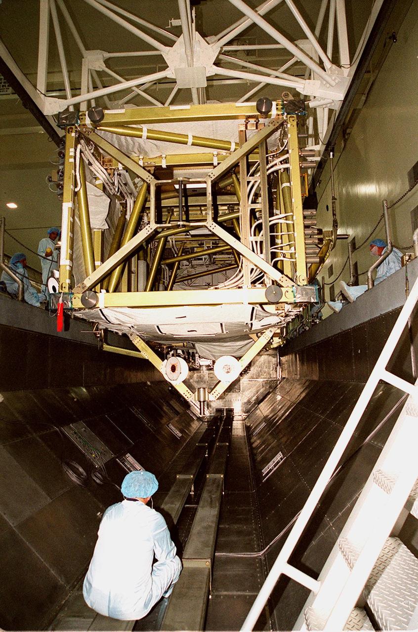 KENNEDY SPACE CENTER, FLA. -- In the Space Station Processing Facility, the P6 integrated truss segment is lowered into the payload transport canister under the watchful eyes of the worker inside the canister as well as the workers on the sides. After being secured in the canister, the truss will be transported to Launch Pad 39B and the payload changeout room. Then it will be moved into Space Shuttle Endeavour’s payload bay for mission STS-97. The P6 comprises Solar Array Wing-3 and the Integrated Electronic Assembly, to be installed on the Space Station. The Station’s electrical power system will use eight photovoltaic solar arrays, each 112 feet long by 39 feet wide, to convert sunlight to electricity. The solar arrays are mounted on a “blanket” that can be folded like an accordion for delivery. Once in orbit, astronauts will deploy the blankets to their full size. Gimbals will be used to rotate the arrays so that they will face the Sun to provide maximum power to the Space Station. The STS-97 launch is scheduled Nov. 30 at 10:06 p.m. EST