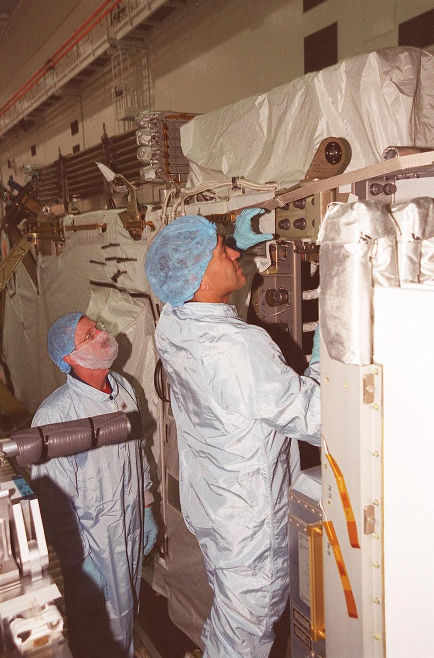 In the Space Station Processing Facility, STS-97 Mission Specialists Carlos Noriega (left) and Joe Tanner check out the mission payload, the P6 integrated truss segment. Mission STS-97 is the sixth construction flight to the International Space Station. The P6 comprises Solar Array Wing-3 and the Integrated Electronic Assembly, to be installed on the International Space Station. The Station’s electrical power system will use eight photovoltaic solar arrays, each 112 feet long by 39 feet wide, to convert sunlight to electricity. The solar arrays are mounted on a “blanket” that can be folded like an accordion for delivery. Once in orbit, astronauts will deploy the blankets to their full size. Gimbals will be used to rotate the arrays so that they will face the Sun to provide maximum power to the Space Station. The mission includes two spacewalks by Noriega and Tanner to complete the solar array connections. STS-97 is scheduled to launch Nov. 30 at about 10:06 p.m. EST