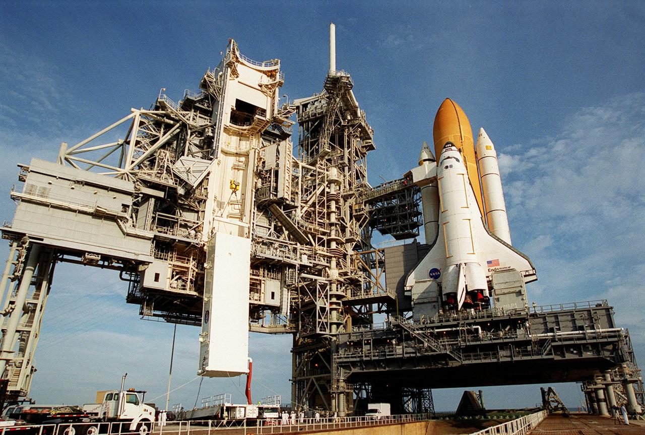 KENNEDY SPACE CENTER, FLA. -- On Launch Pad 39B, the payload transport canister, with the P6 integrated truss segment inside, moves higher toward the payload changeout room (PCR). The PCR is the enclosed, environmentally controlled portion of the Rotating Service Structure (RSS) (at left) that supports payload delivery at the pad. At right is Space Shuttle Endeavour with its orange external tank and solid rocket boosters showing behind it. When the RSS is closed around Endeavour, the P6 truss will be able to be moved into the orbiter’s payload bay. The P6, payload on mission STS-97, comprises Solar Array Wing-3 and the Integrated Electronic Assembly, to be installed on the International Space Station. The Station’s electrical power system will use eight photovoltaic solar arrays, each 112 feet long by 39 feet wide, to convert sunlight to electricity. The solar arrays are mounted on a “blanket” that can be folded like an accordion for delivery. Once in orbit, astronauts will deploy the blankets to their full size. Gimbals will be used to rotate the arrays so that they will face the Sun to provide maximum power to the Space Station. Launch of STS-97 is scheduled for Nov. 30 at 10:06 p.m. EST