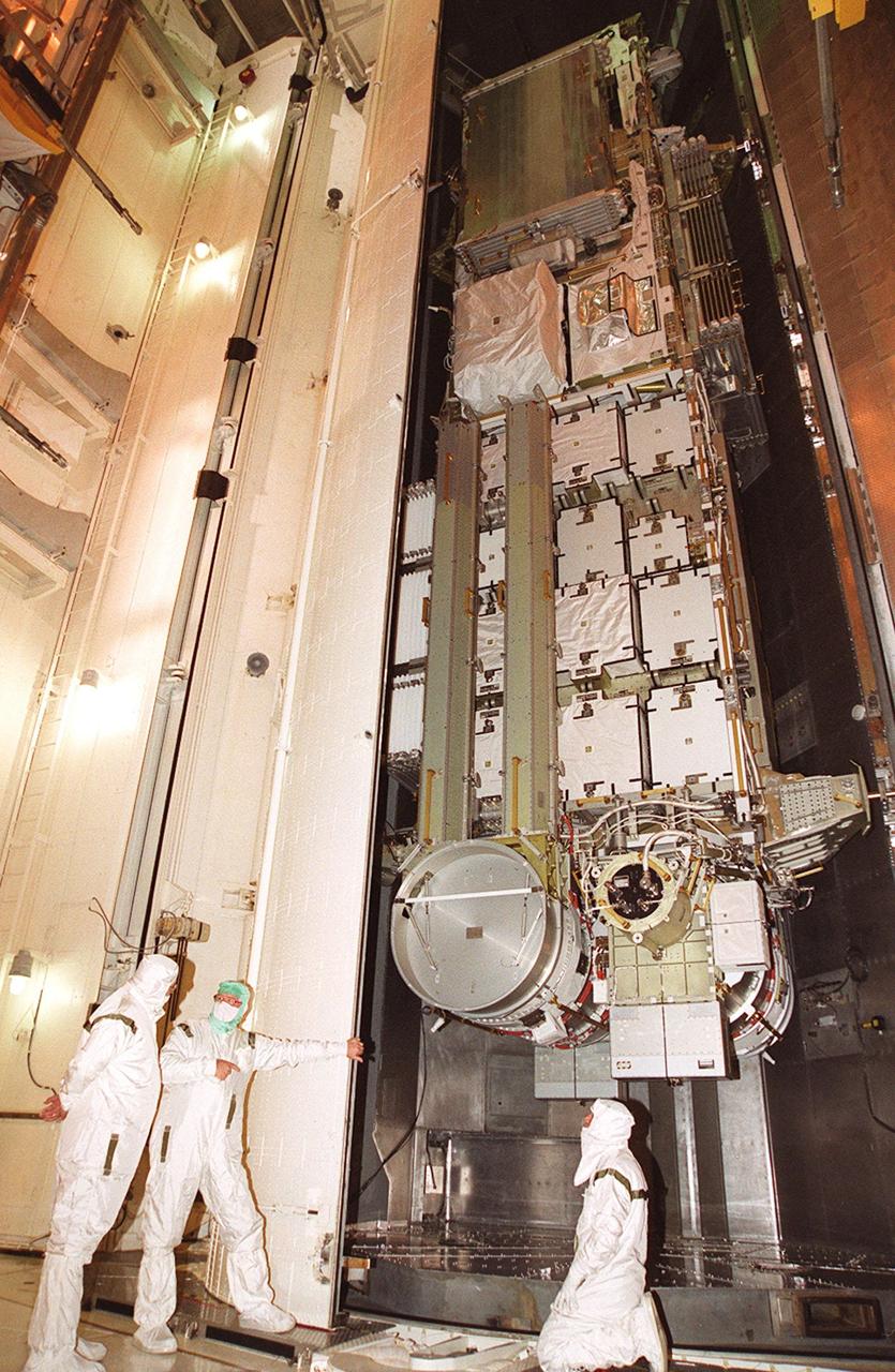 Workers in the payload changeout room stand by as the doors open on the payload transport canister. Inside is the P6 integrated truss segment, which will fly on mission STS-97. The P6 comprises Solar Array Wing-3 and the Integrated Electronic Assembly, to be installed on the International Space Station. The Station’s electrical power system will use eight photovoltaic solar arrays, each 112 feet long by 39 feet wide, to convert sunlight to electricity. The solar arrays are mounted on a “blanket” that can be folded like an accordion for delivery. Once in orbit, astronauts will deploy the blankets to their full size. Gimbals will be used to rotate the arrays so that they will face the Sun to provide maximum power to the Space Station. Launch of STS-97 is scheduled for Nov. 30 at 10:06 p.m. EST