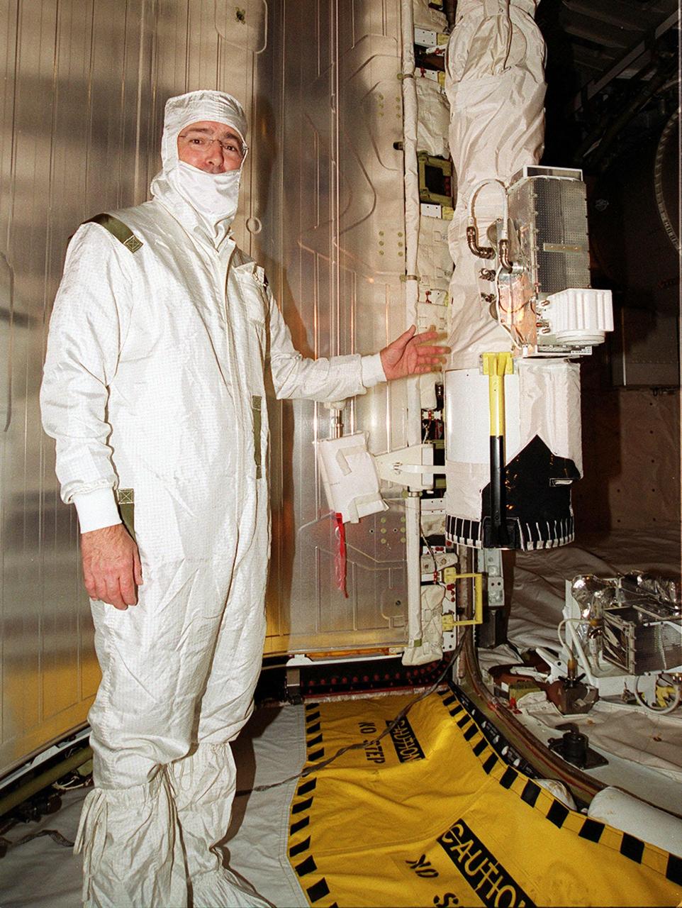 STS-97 Mission Specialist Marc Garneau points to Endeavour's robotic arm that he will use during a spacewalk on the mission. Members of the STS-97 crew are taking part in a payload walkdown from the payload changeout room at Launch Pad 39B. The payload comprises the P6 Integrated Truss Segment, with solar arrays that will be temporarily installed on the recently delivered Z1 truss, connecting them to the Unity module, and batteries. The two solar arrays are each more than 100 feet long. They will capture energy from the sun and convert it to power for the Station. Two spacewalks will be required to install the solar array connections. STS-97 is scheduled to launch Nov. 30 at about 10:06 p.m. EST