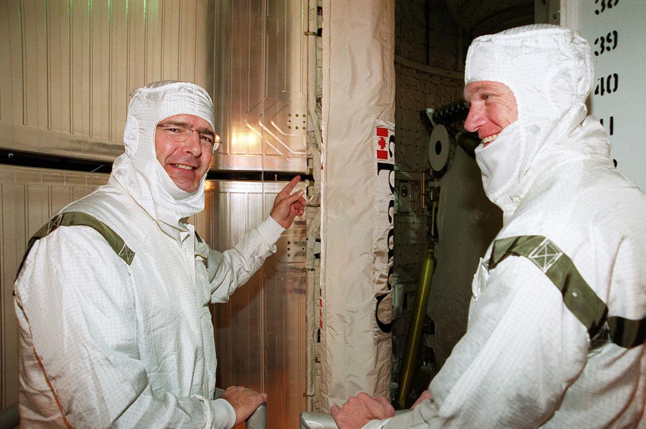 STS-97 Mission Specialist Marc Garneau, who is with the Canadian Space Agency, points to the Canadian robotic arm he will be working with during spacewalks to install solar arrays. At right is Commander Brent Jett. The arrays are part of the P6 Integrated Truss Segment that will be temporarily installed on the recently delivered Z1 truss, connecting them to the Unity module. Each more than 100 feet long, the arrays will capture energy from the sun and convert it to power for the Station. STS-97 is scheduled to launch Nov. 30 at about 10:06 p.m. EST