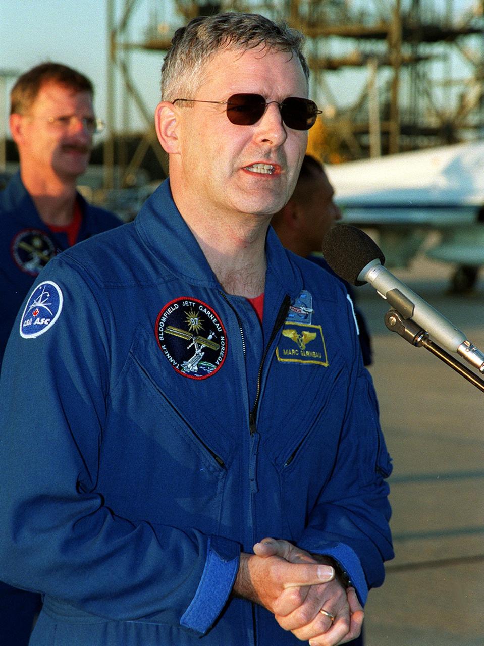 After arriving at the Shuttle Landing Facility, the STS-97 crew gather to address the media. At the microphone is Mission Specialist Marc Garneau, who is with the Canadian Space Agency. Behind him can be seen Mission Specialists Joseph Tanner (left) and Carlos Noriega. Mission STS-97 is the sixth construction flight to the International Space Station. Its payload includes the P6 Integrated Truss Structure and a photovoltaic (PV) module, with giant solar arrays that will provide power to the Station. The mission includes two spacewalks to complete the solar array connections. STS-97 is scheduled to launch Nov. 30 at about 10:06 p.m. EST