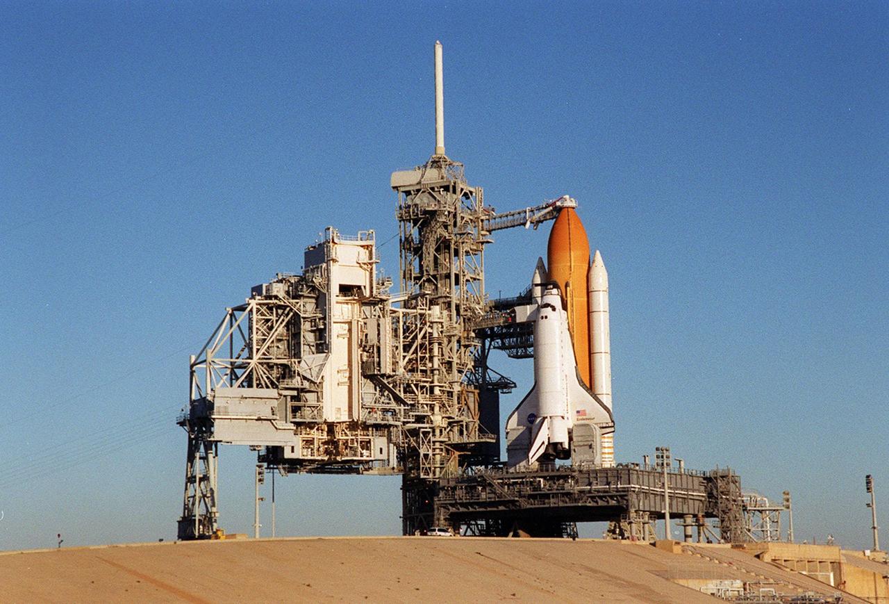Against a cloudless blue sky, Space Shuttle Endeavour stands ready for launch after the rollback of the Rotating Service Structure, at left. Endeavour is targeted for launch tonight at about 10:06 p.m. EST on mission STS-97 to the International Space Station. The orbiter carries the P6 Integrated Truss Segment containing solar arrays that will be temporarily installed to the Unity connecting module by the Z1 truss, recently delivered to and installed on the Station on mission STS-92. The two solar arrays are each more than 100 feet long. They will capture energy from the sun and convert it to power for the Station. Two spacewalks will be required to install the solar array connections