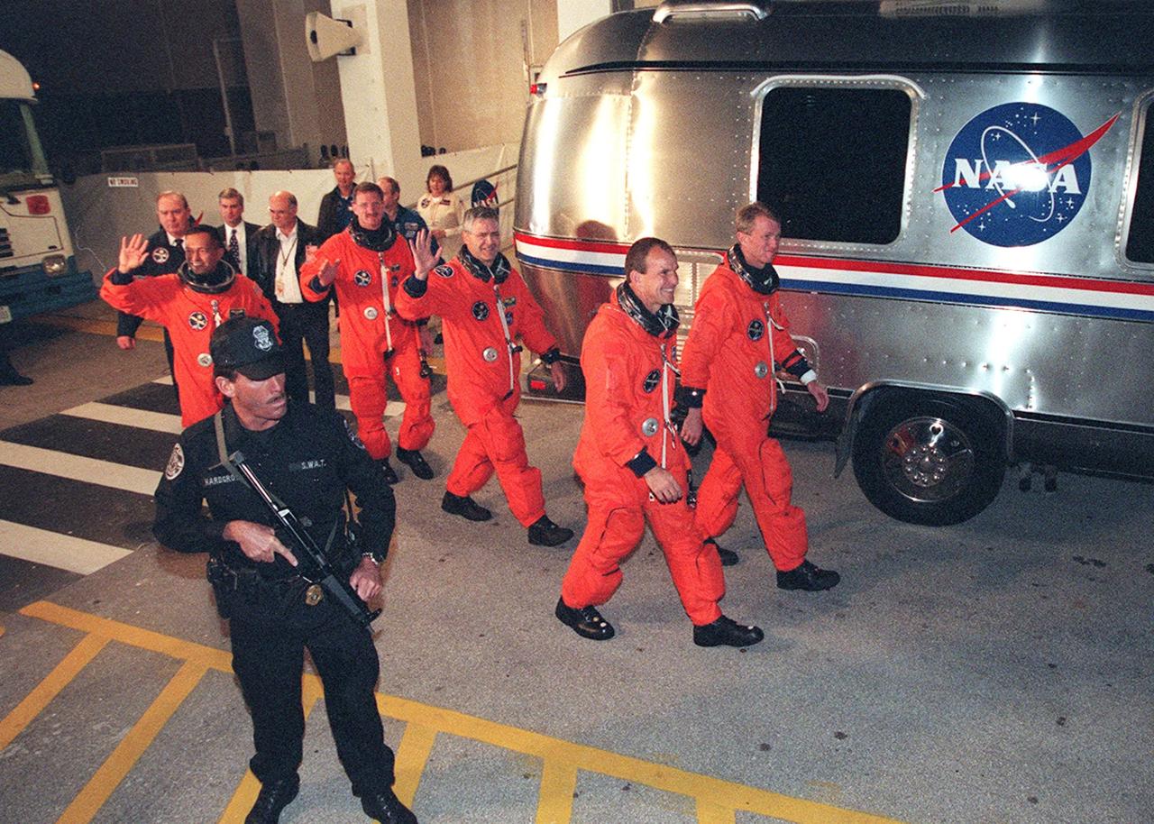 Leaving the Operations and Checkout Building, the STS-97 crew hurries toward the waiting Astrovan that will take them to Launch Pad 39B. Starting at left, they are Mission Specialists Carlos Noriega, Joseph Tanner and Marc Garneau; Pilot Michael Bloomfield; and Commander Brent Jett. Garneau is with the Canadian Space Agency. Mission STS-97 is the sixth construction flight to the International Space Station. It is transporting the P6 Integrated Truss Structure that comprises Solar Array Wing-3 and the Integrated Electronic Assembly, to be installed on the Space Station. The solar arrays are mounted on a “blanket” that can be folded like an accordion for delivery. Once in orbit, astronauts will deploy the blankets to their full size. The 11-day mission includes two spacewalks to complete the solar array connections. The Station’s electrical power system will use eight photovoltaic solar arrays, each 112 feet long by 39 feet wide, to convert sunlight to electricity. Gimbals will be used to rotate the arrays so that they will face the Sun to provide maximum power to the Space Station. Launch is scheduled for Nov. 30 at 10:06 p.m. EST