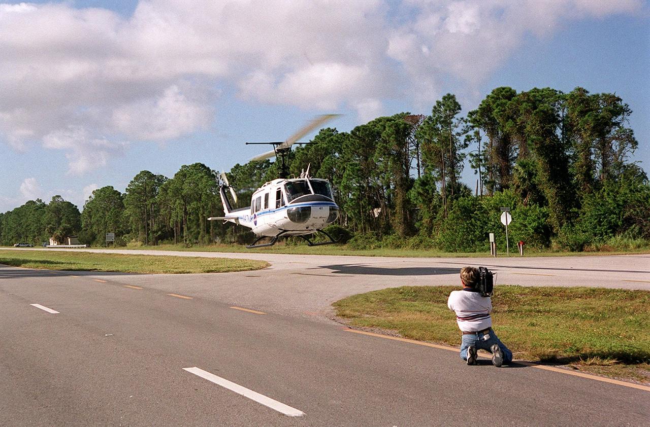 KENNEDY SPACE CENTER, FLA. -- At S.R. 3 a NASA helicopter lifts off to return to Patrick Air Force Base. The helicopter is one of four UH-1H helicopters that have had its blades painted, changing the previous black color to a pattern of white and yellow stripes. The pattern provides better visibility in smoke and fire conditions. When the rotors are turning, the stripes create a yellow and white circle that is more easily seen by a second helicopter from above. The helicopters, primarily used for security and medical evacuation for NASA, will be used to deliver water via buckets during brush fires. The change was made to comply with U.S. Fish and Wildlife and Department of Forestry regulations for helicopter-assisted fire control