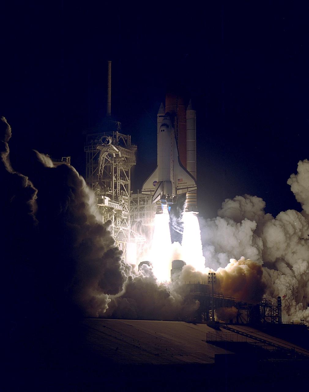 KENNEDY SPACE CENTER, Fla.  --  Twin columns of flame spew from the solid rocket boosters lifting Space Shuttle Endeavour out of the smoke and steam and into the night sky. Liftoff occurred on time at 10:06:01 p.m. EST. The Shuttle and its five-member crew will deliver U.S. solar arrays to the International Space Station and be the first Shuttle crew to visit the Station’s first resident crew. The 11-day mission includes three spacewalks. This marks the 101st mission in Space Shuttle history and the 25th night launch. Endeavour is expected to land at KSC Dec. 11 at 6:19 p.m. EST