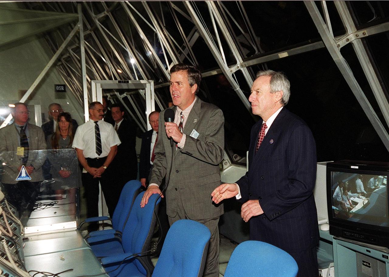 KENNEDY SPACE CENTER, FLA. -- Florida Governor Jeb Bush (with microphone) addresses the launch team in the Firing Room, Launch Control Center, after a successful launch of STS-97. At right is NASA Administrator Daniel Goldin. Liftoff of Space Shuttle Endeavour occurred at 10:06:01 p.m. Endeavour and its five-member crew will deliver U.S. solar arrays to the International Space Station and be the first Shuttle crew to visit the Station’s first resident crew. The 11-day mission includes three spacewalks. This marks the 101st mission in Space Shuttle history and the 25th night launch. Endeavour is expected to land at KSC Dec. 11 at 6:19 p.m. EST