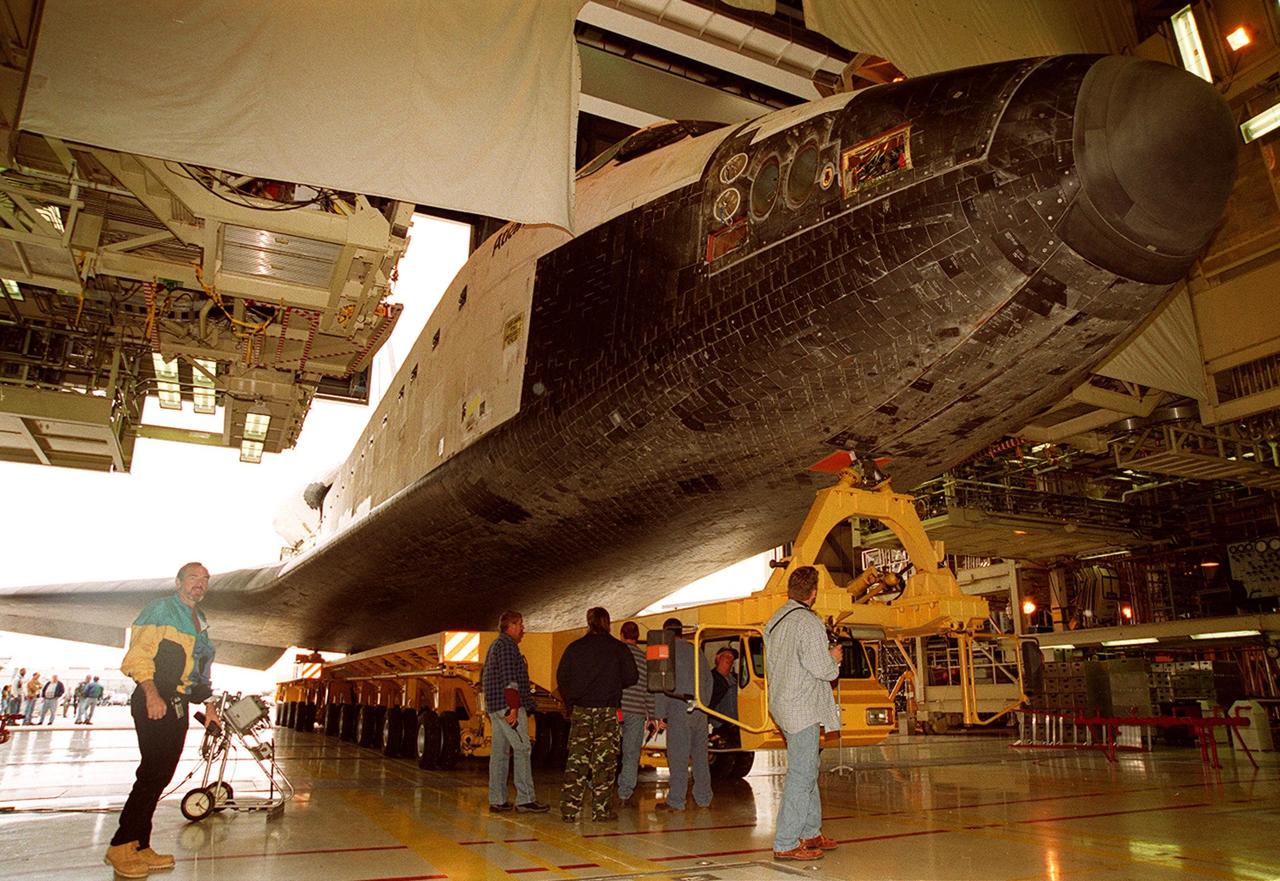 Viewed from inside Orbiter Processing Facility bay 3, Atlantis is ready for rollover to the Vehicle Assembly Building. In the VAB it will be raised to vertical and lifted up and into high bay 3 for stacking with its external tank and solid rocket boosters. Atlantis will fly on mission STS-98, the seventh construction flight to the International Space Station. The orbiter will carry in its payload bay the U.S. Laboratory, named Destiny, that will have five system racks already installed inside of the module. After delivery of electronics in the lab, electrically powered attitude control for Control Moment Gyroscopes will be activated. Atlantis is scheduled for launch on Jan. 18, 2001, at 2:44 a.m. EST, with a crew of five