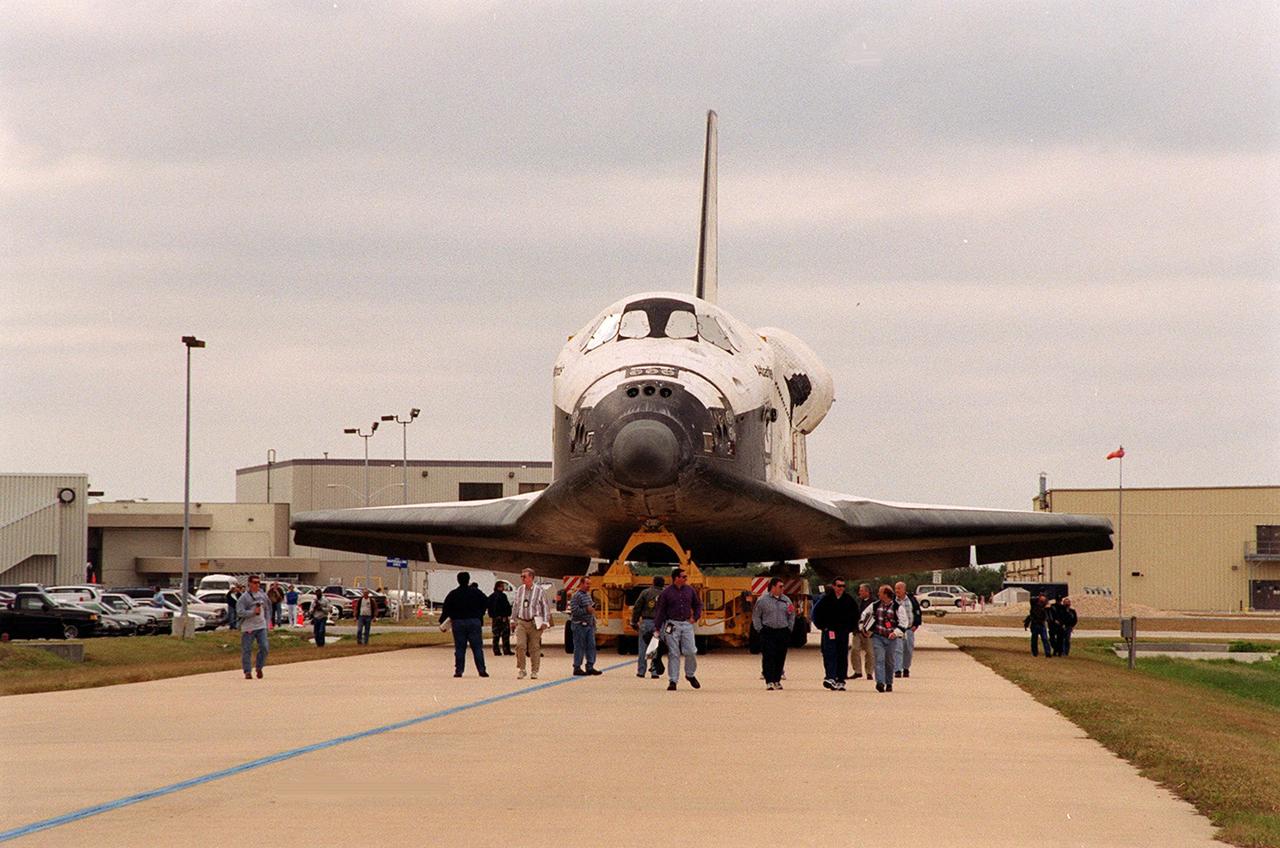 The orbiter Atlantis rolls away from the Orbiter Processing Facility bay 3 (in the background) to the Vehicle Assembly Building. In the VAB it will be raised to vertical and lifted up and into high bay 3 for stacking with its external tank and solid rocket boosters. Atlantis will fly on mission STS-98, the seventh construction flight to the International Space Station. The orbiter will carry in its payload bay the U.S. Laboratory, named Destiny, that will have five system racks already installed inside of the module. After delivery of electronics in the lab, electrically powered attitude control for Control Moment Gyroscopes will be activated. Atlantis is scheduled for launch on Jan. 18, 2001, at 2:44 a.m. EST, with a crew of five
