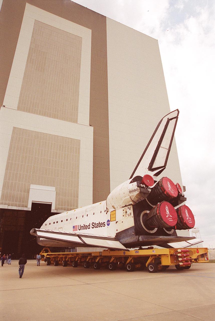 The orbiter Atlantis rolls toward the open door of the Vehicle Assembly Building after leaving the Orbiter Processing Facility bay 3. In the VAB it will be raised to vertical and lifted up and into high bay 3 for stacking with its external tank and solid rocket boosters. Atlantis will fly on mission STS-98, the seventh construction flight to the International Space Station. The orbiter will carry in its payload bay the U.S. Laboratory, named Destiny, that will have five system racks already installed inside of the module. After delivery of electronics in the lab, electrically powered attitude control for Control Moment Gyroscopes will be activated. Atlantis is scheduled for launch on Jan. 18, 2001, at 2:44 a.m. EST, with a crew of five