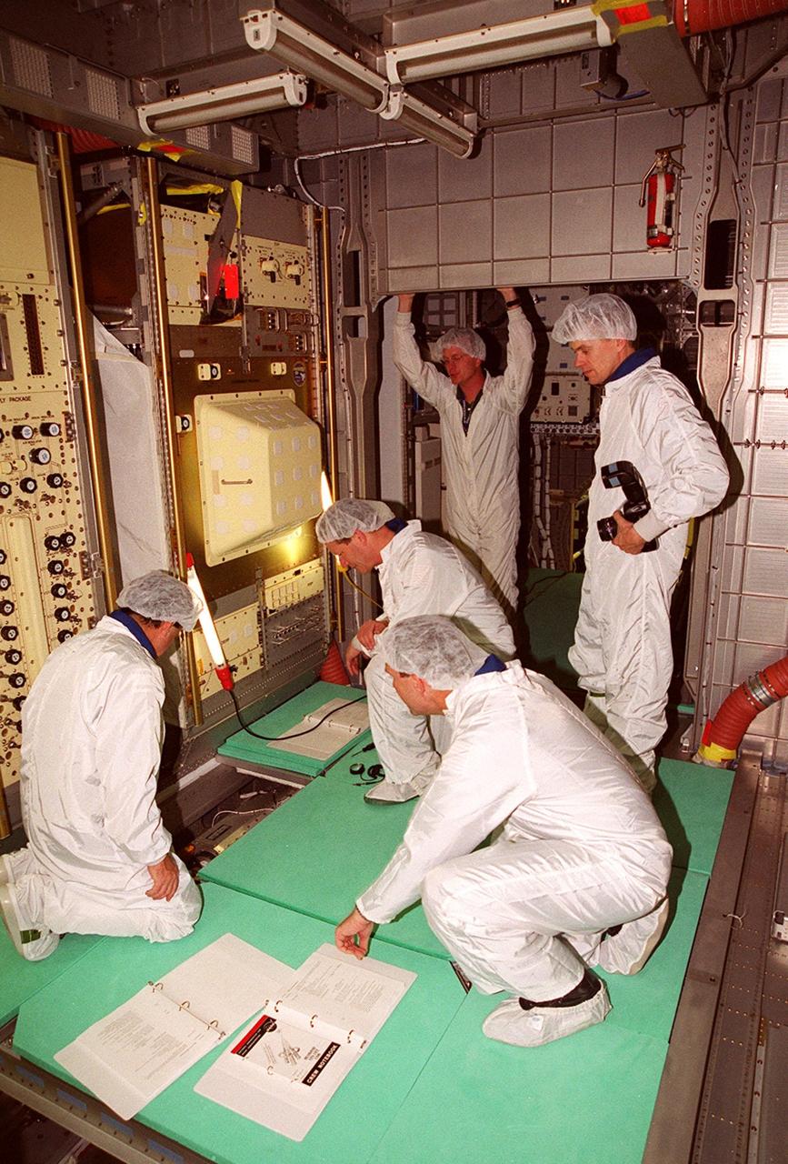 KENNEDY SPACE CENTER, Fla. -- Members of the STS-107 crew take part in In-Flight Maintenance training for their mission. One of the payload elements on the mission is the SPACEHAB Double Module in its first research flight into space. Working with equipment inside the SPACEHAB Double Module are (front) Payload Specialist Ilan Ramon (left), astronaut from Israel, and Commander Rick D. Husband; (back) Mission Specialist David Brown, SPACEHAB trainer David Butler, and Pilot William C. “Willie” McCool. Research mission STS-107 is scheduled to launch July 19, 2001
