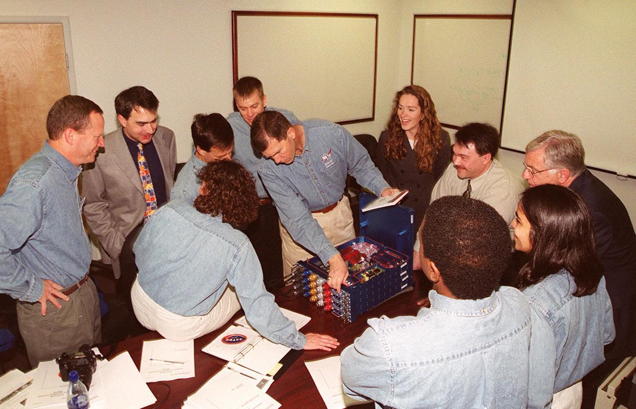 KENNEDY SPACE CENTER, FLA. -- Members of the STS-107 crew take part in In-Flight Maintenance training for their mission. As a research mission, STS-107 will carry the SPACEHAB Double Module in its first research flight into space and a broad collection of experiments ranging from material science to life science. Looking over an experiment are (left to right) Mission Specialist David M. Brown and Laurel Clark (back to camera), Payload Specialist Ilan Ramon of Israel and Commander Rick D. Husband; Pilot William C. “Willie” McCool is behind them. Looking on are project engineers and scientists. At right are Mission Specialists Michael Anderson and Kalpana Chawla. STS-107 is scheduled to launch July 19, 2001