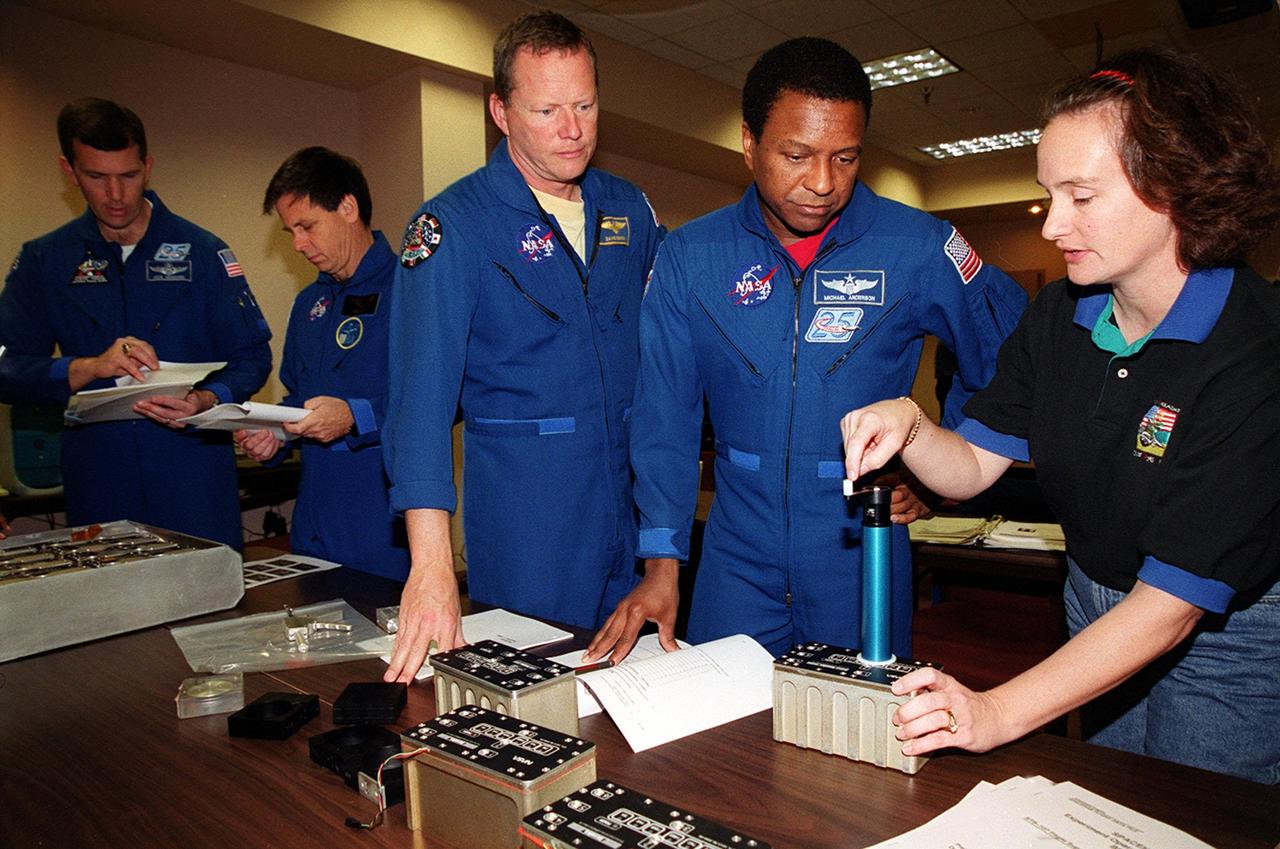 KENNEDY SPACE CENTER, FLA. -- As part of In-Flight Maintenance training at SPACEHAB, in Cape Canaveral, Fla., members of the STS-107 crew learn about Biological Research in Canisters (BRIC) experiments that will be on their mission. From left Commander Rick D. Husband and Payload Specialist Ilan Ramon of Israel look over paperwork. Mission Specialists David M. Brown and Michael Anderson (center) look at the way Debbie Wells of Bionetics manipulates part of the equipment. STS-107 will carry a broad collection of experiments ranging from material science to life science. It is scheduled to launch July 19, 2001