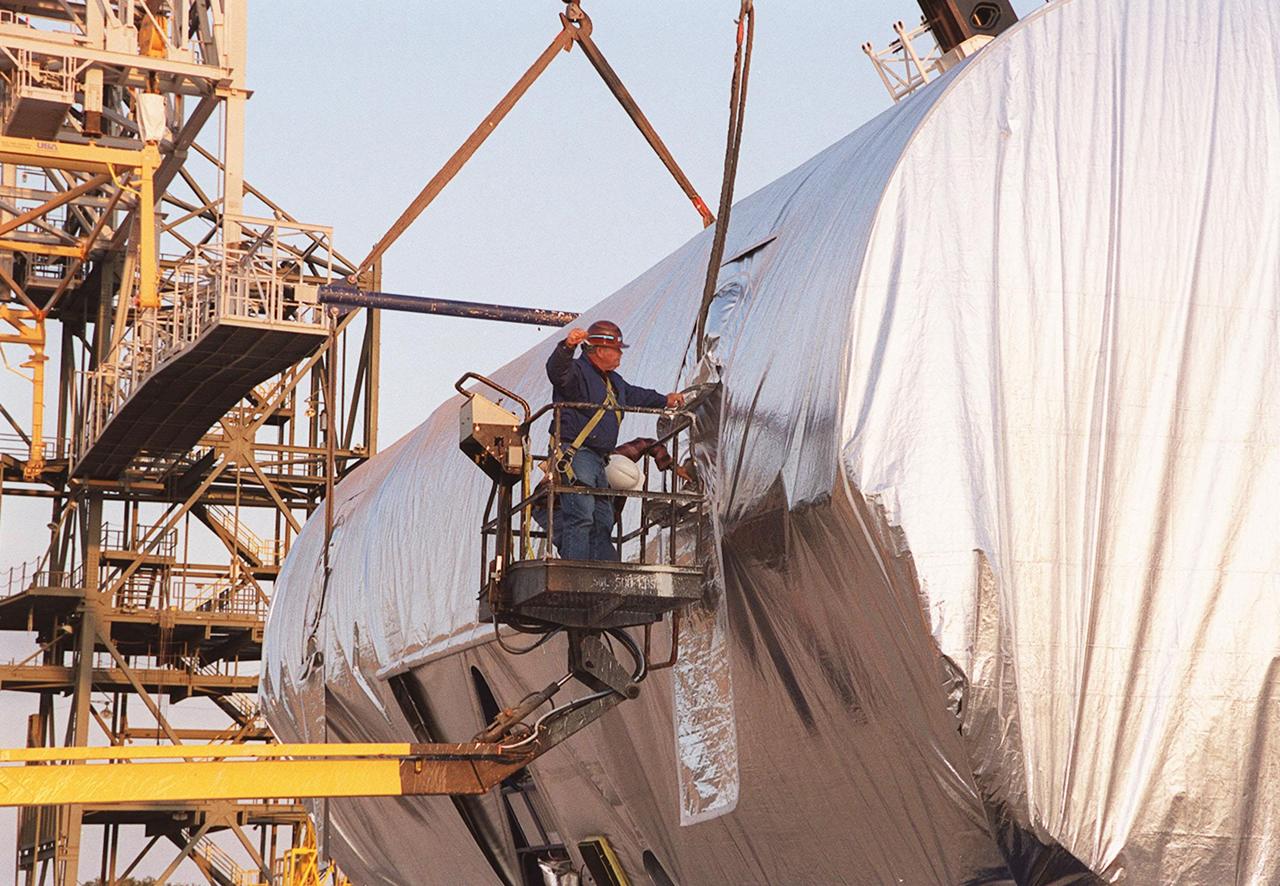 At the Shuttle Landing Facility, a worker attaches one of the cranes to the Integrated Truss Structure S3. Cranes will lift and move the truss to a transporter and take it to the Operations and Checkout Building. The second starboard truss segment of the International Space Station, the S3 truss is scheduled to be added to the Station in April 2003