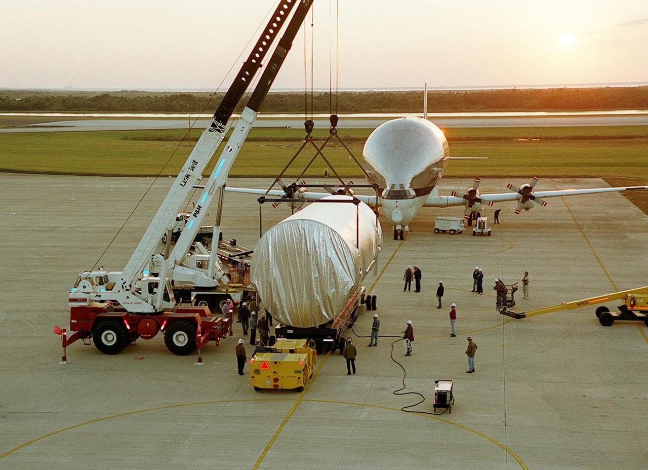 On the parking apron of the Shuttle Landing Facility, workers check the overhead cranes that will move the Integrated Truss Structure S3 to a transporter. The truss will be taken to the Operations and Checkout Building. The second starboard truss segment of the International Space Station, the S3 truss is scheduled to be added to the Station in April 2003