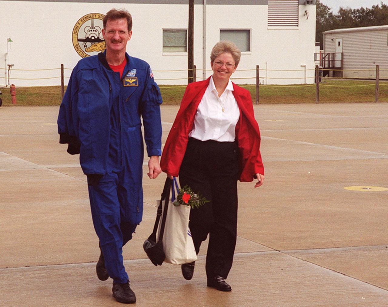KENNEDY SPACE CENTER, FLA. -- After a night’s rest and a brief press conference at KSC, STS-97 Mission Specialist Joseph Tanner heads for the plane at the Shuttle Landing Facility. With him is his wife. They and other crew members and their families are returning to Houston. Mission STS-97 ended on Dec. 11, 2000, with a landing at KSC at 6:04 p.m. EST