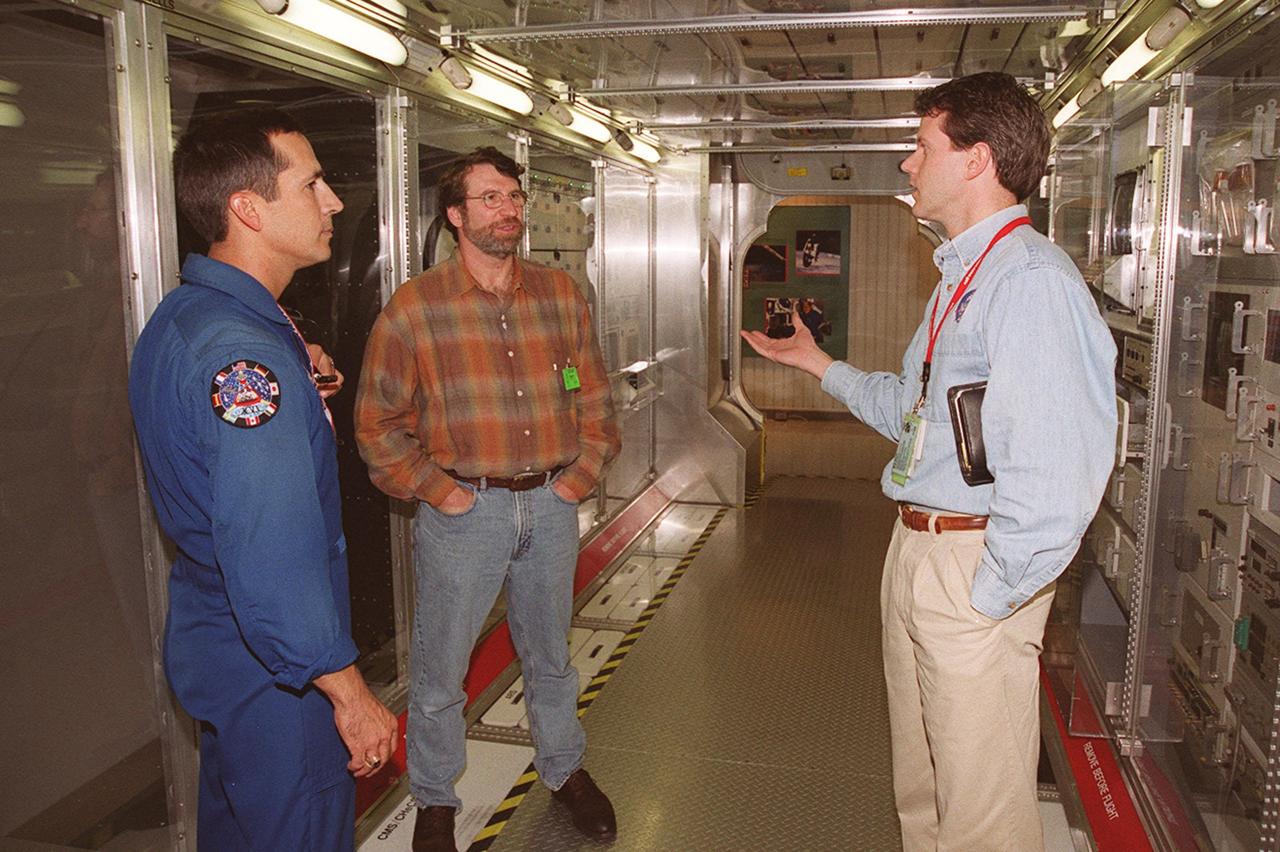 KENNEDY SPACE CENTER, FLA. --  Astronaut John Herrington (left) and Norm Abram, of television’s "This Old House" and "The New Yankee Workshop," talk to Phil West, of Johnson Space Center. They are standing in front of a mockup of the U.S. Lab, located in the International Space Station Center, a tour facility.. Abram is at KSC to film an episode of "This Old House.