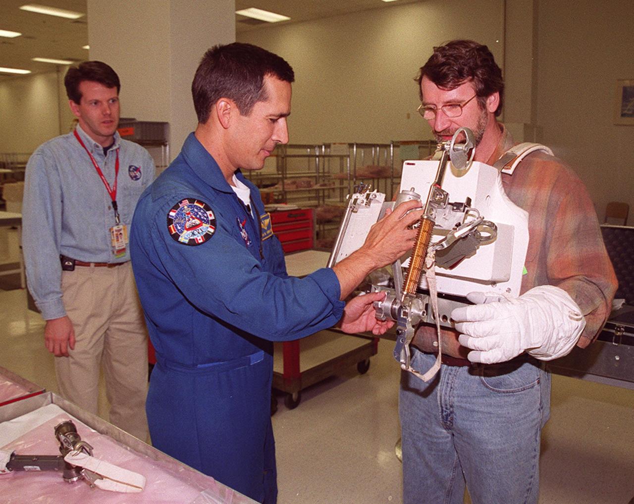 KENNEDY SPACE CENER, FLA. --  Norm Abram, master carpenter of television’s "This Old House" and "The New Yankee Workshop," tries out a tool used in space while wearing gloves that are part of the spacewalking suits. Abram is at KSC to film an episode of "This Old House.