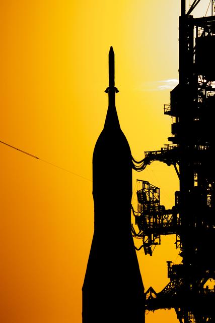 The sun sets as NASA’s crawler-transporter 2 carrying the agency’s Artemis II...