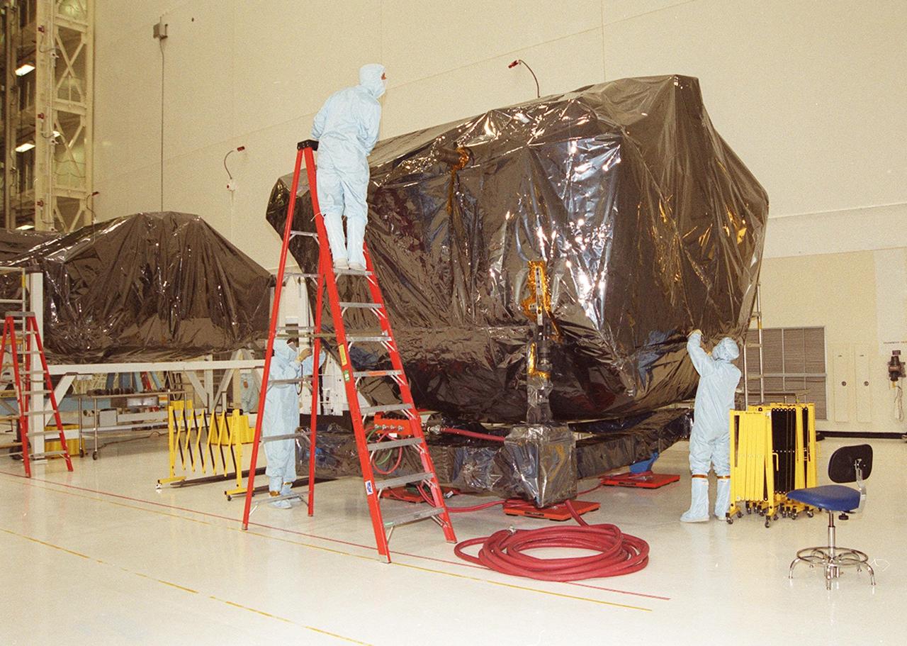 KENNEDY SPACE CENTER, Fla. --  Workers in the Vertical Processing Facility begin to unwrap the payload that recently arrived for STS-109, whose mission is servicing the Hubble Space Telescope.  The primary servicing tasks of the mission are to replace Solar Array 2 with Solar Array 3, replace the Power Control Unit, remove the Faint Object Camera and install the Advanced Camera for Surveys, install the NICMOS Cooling System, and install New Outer Blanket Insulation on bays 5 through 8.  Mission STS-109 is scheduled for launch in mid-February 2002