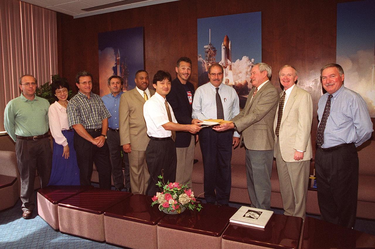 KENNEDY SPACE CENTER, Fla. --  In a special presentation, ISS International Partners donate funds to the Combined Federal Campaign and United Way at KSC to benefit the Sept. 11 recovery efforts.  From left are Francesco Santoro of Alenia (Italian Space Agency contractor), Minako Holdrum of the Natinal Space Development Agency of Japan (NASDA), Michele Tripoli and Guiseppe Mancuso of Alenia, Todd Arnold, NASA KSC, Shimpei Takahashi of NASDA, Steve Mozes of the Canadian Space Agency, Agostino Verghini of the Italian Space Agency, Frank Ramsey of United Way/CFC, Center Director Roy D. Bridges Jr. and Director of International Space Station/Payload Processing Tip Talone