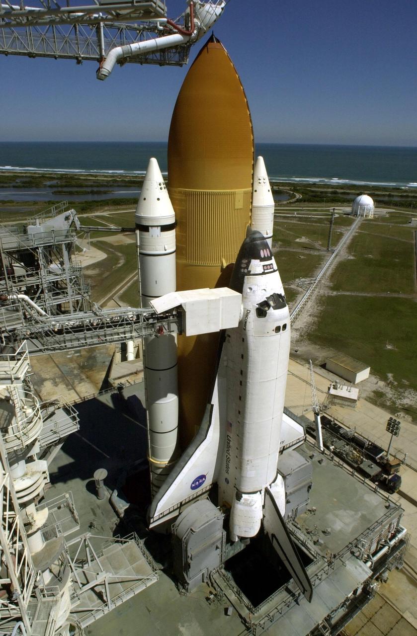 Space Shuttle Discovery sits poised on Launch Pad 39B, ready for launch at 6:42 a.m. EST March 8 on mission STS-102. Situated above the external tank is the Gaseous Oxygen Vent Arm with the “beanie cap,” a vent hood. The orbiter access arm is extended from the Fixed Service Structure (left) to the orbiter. An environmentally controlled chamber, known as the White Room, is at the end of the arm, providing entrance for the astronaut crew into the orbiter. In the distance, behind the Space Shuttle, can be seen the Atlantic Ocean. On this eighth construction flight to the International Space Station, Discovery carries the Multi-Purpose Logistics Module Leonardo, the primary delivery system used to resupply and return Station cargo requiring a pressurized environment. Leonardo will deliver up to 10 tons of laboratory racks filled with equipment, experiments and supplies for outfitting the newly installed U.S. Laboratory Destiny