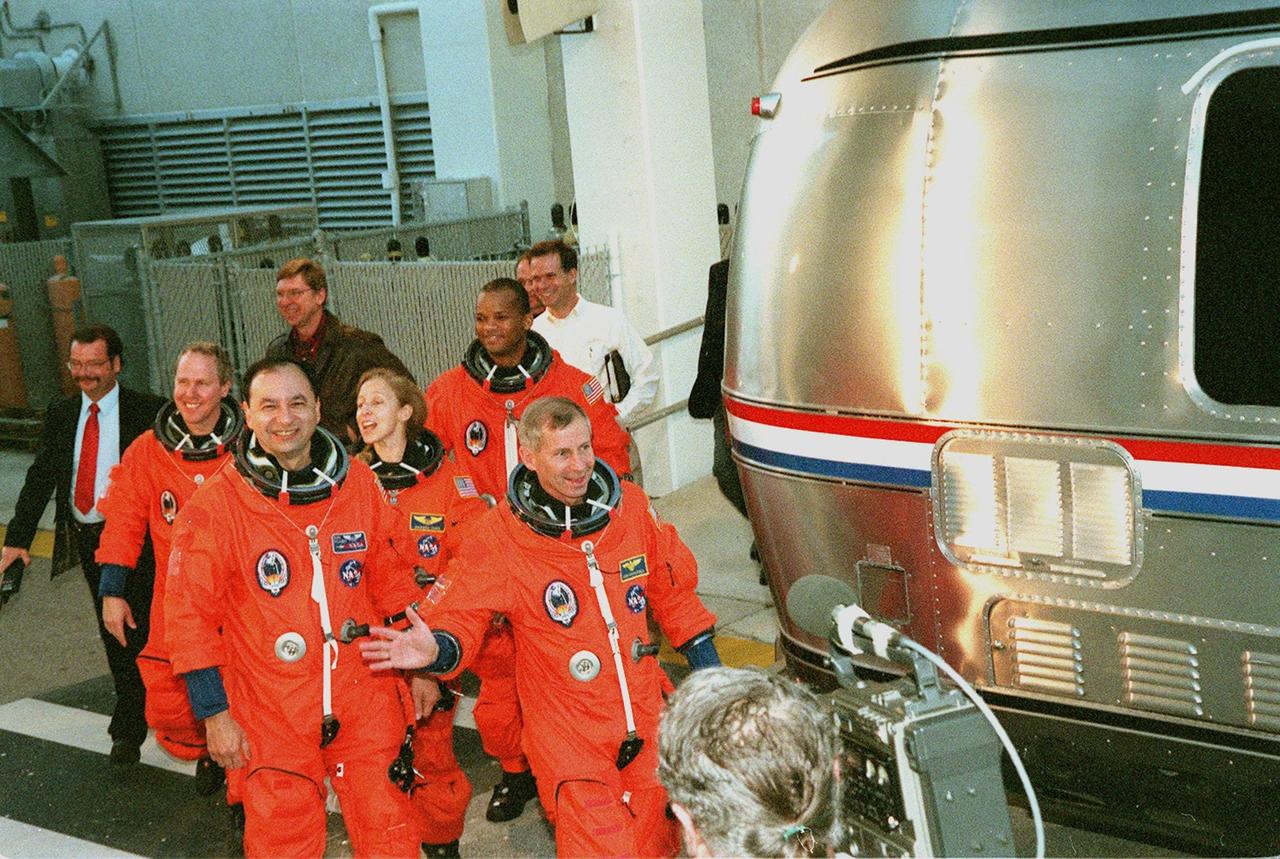 The STS-98 crew wave to onlookers as they walk out of the Operations and Checkout Building dressed for a simulated launch countdown at Launch Pad 39A. From left to right, they are Mission Specialist Thomas Jones, Pilot Mark Polansky, Mission Specialists Marsh Ivins and Robert Curbeam, being led by Commander Ken Cockrell. The crew is taking part in Terminal Countdown Demonstration Test activities, which include the countdown and emergency egress training at the pad. STS-98 is the seventh construction flight to the International Space Station, carrying as payload the U.S. Lab Destiny, a key element in the construction of the ISS. Launch of STS-98 is scheduled for Jan. 19 at 2:11 a.m. EST