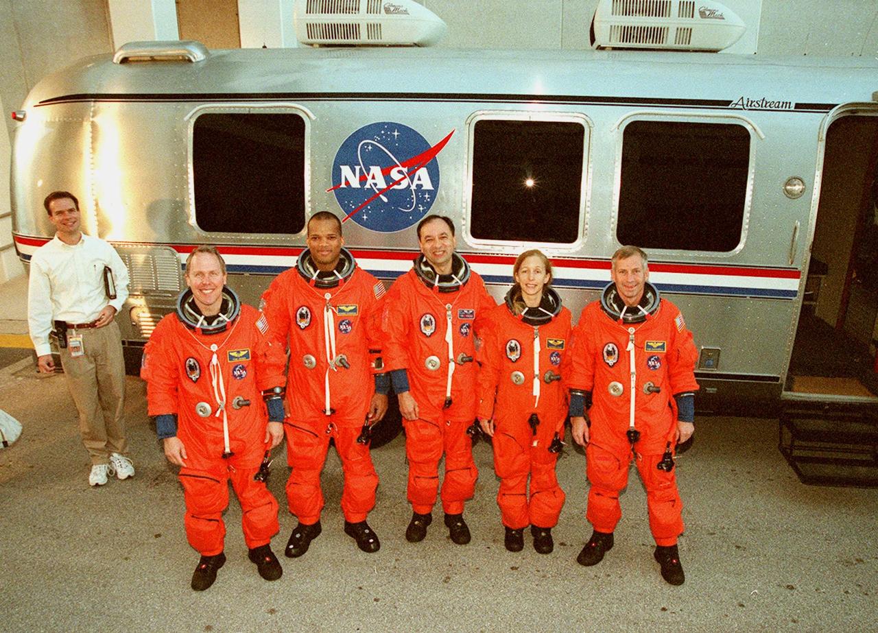 After walkout from the Operations and Checkout Building, the <a href="../../subjects/sts-98.htm"> STS-98</a> crew stops for a photograph in front of the Astrovan that will take them to <a href="../../subjects/lc39a.htm"> Launch Pad 39A</a> for a simulated launch countdown. Standing left to right are Mission Specialists Thomas Jones and Robert Curbeam, Pilot Mark Polansky, Mission Specialist Marsha Ivins and Commander Ken Cockrell. The crew has been taking part in Terminal Countdown Demonstration Test activities, which include the simulated countdown and emergency egress training at the pad. STS-98 is the seventh construction flight to the International Space Station, carrying as payload the U.S. Lab <a href="../../subjects/destiny.htm">Destiny</a>, a key element in the construction of the ISS. Launch of STS-98 is scheduled for Jan. 19 at 2:11 a.m. EST
