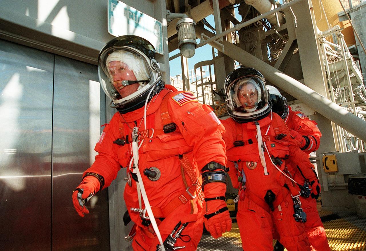 Fully dressed in their launch and entry suits, STS-98 Mission Specialists Thomas Jones (left), Marsha Ivins and Robert Curbeam practice a speedy exit from the Fixed Service Structure during emergency egress training. They are heading for the slidewire baskets that slide along a 1200-foot wire to the landing zone below and nearby bunker. The crew has been taking part in Terminal Countdown Demonstration Test activities, which include the simulated countdown and emergency egress training at the pad. STS-98 is the seventh construction flight to the International Space Station, carrying as payload the U.S. Lab Destiny, a key element in the construction of the ISS. Launch of STS-98 is scheduled for Jan. 19 at 2:11 a.m. EST