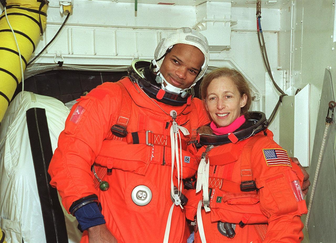 In the White Room, STS-98 Mission Specialists Robert Curbeam and Marsha Ivins pose for a photo before entering Atlantis for a simulated launch countdown. The White Room is an environmental chamber at the end of the orbiter access arm that mates with the orbiter to allow personnel to enter the orbiter’s crew compartment. The STS-98 crew is taking part in Terminal Countdown Demonstration Test activities, which also include emergency egress training at the pad. STS-98 is the seventh construction flight to the International Space Station, carrying as payload the U.S. Lab Destiny, a key element in the construction of the ISS. Launch of STS-98 is scheduled for Jan. 19 at 2:11 a.m. EST