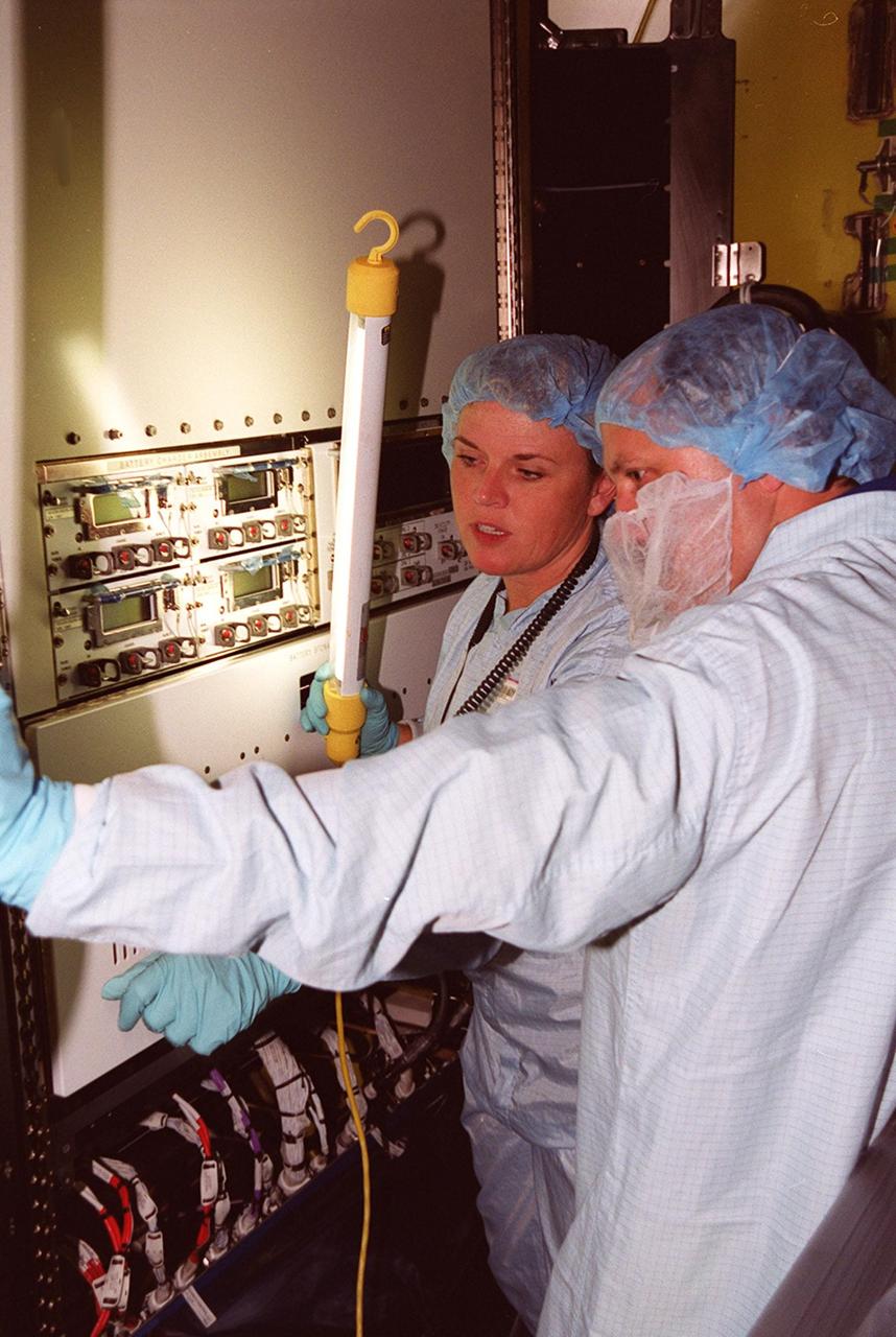 Inside the air lock in the Space Station Processing Facility, a technician points out equipment to cosmonaut Yury Usachev (right), who is part of the Expedition Two crew going to the International Space Station. Usachev and other crew members astronauts Susan Helms and James Voss will be flying on mission STS-102, launching March 8. The air lock will be carried to the Station during their tenure in space. STS-102 will be Helms’ and Voss’s fifth Shuttle flight, and Usachev’s second. They will be replacing the Expedition One crew (Bill Shepherd, Yuri Gidzenko and Sergei Krikalev), who will return to Earth March 20 on Discovery along with the STS-102 crew