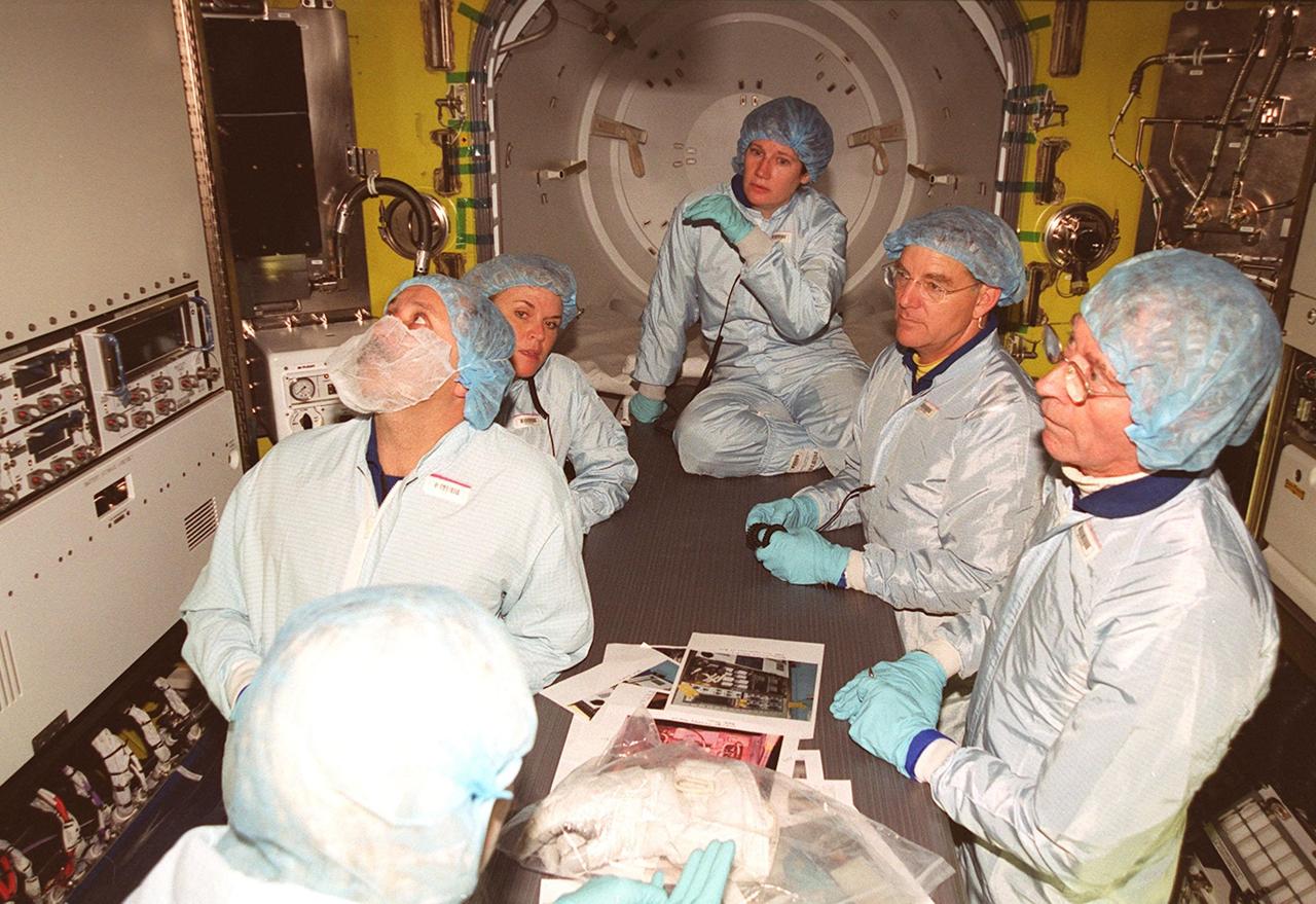 Inside the air lock in the Space Station Processing Facility, the Expedition Two crew look at equipment. Seen from left are cosmonaut Yury Usachev, a technician, and astronauts Susan Helms and James Voss. At far right is astronaut John Young, who flew on mission STS-1. Usachev, Helms and Voss will be flying on mission STS-102, launching March 8. The air lock will be carried to the Station during their tenure in space. STS-102 will be Helms’ and Voss’s fifth Shuttle flight, and Usachev’s second. They will be replacing the Expedition One crew (Bill Shepherd, Yuri Gidzenko and Sergei Krikalev), who will return to Earth March 20 on Discovery along with the STS-102 crew