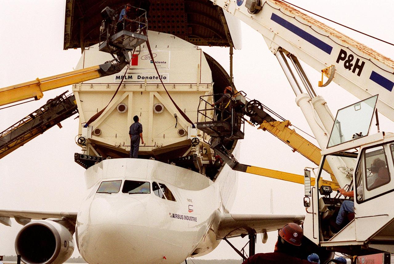 At the <a href="../../subjects/slf.htm"> Shuttle Landing Facility</a>, cranes are poised to help offload the Italian Space Agency’s <a href="../../subjects/mplm.htm"> Multi-Purpose Logistics Module</a> Donatello from the Airbus “Beluga” air cargo plane that brought it from the factory of Alenia Aerospazio in Turin, Italy. The third of three for the <a href="../../subjects/iss.htm"> International Space Station</a>, the module will be transported to the <a href="../../subjects/sspf.htm"> Space Station Processing Facility</a> for processing. Among the activities for the payload test team are integrated electrical tests with other Station elements in the SSPF, leak tests, electrical and software compatibility tests with the Space Shuttle (using the Cargo Integrated Test equipment) and an Interface Verification Test once the module is installed in the Space Shuttle’s payload bay at the launch pad. The most significant mechanical task to be performed on Donatello in the SSPF is the installation and outfitting of the racks for carrying the various experiments and cargo