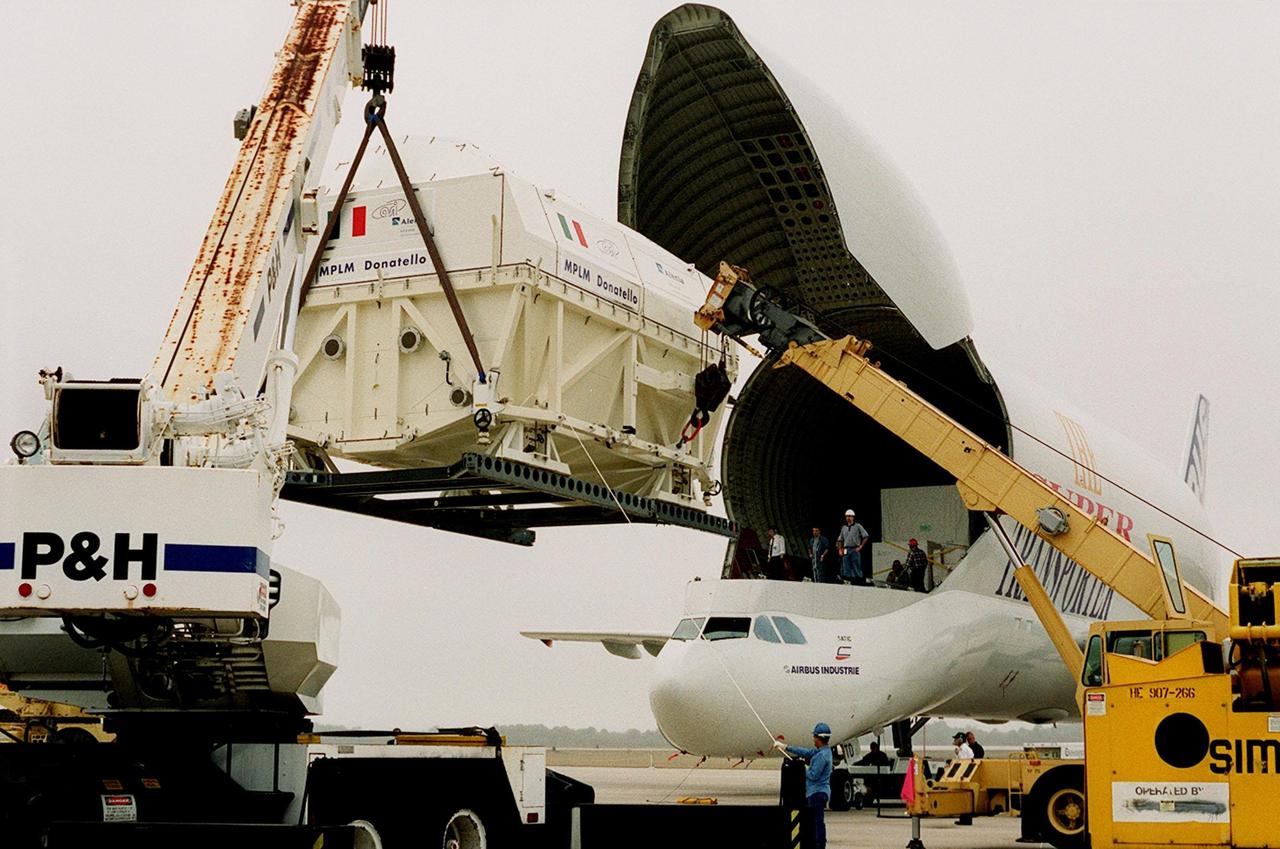 At the Shuttle Landing Facility, cranes help offload the Italian Space Agency’s Multi-Purpose Logistics Module Donatello from the Airbus “Beluga” air cargo plane. The third of three for the International Space Station, the module will be moved on a transporter to the Space Station Processing Facility for processing. Among the activities for the payload test team are integrated electrical tests with other Station elements in the SSPF, leak tests, electrical and software compatibility tests with the Space Shuttle (using the Cargo Integrated Test equipment) and an Interface Verification Test once the module is installed in the Space Shuttle’s payload bay at the launch pad. The most significant mechanical task to be performed on Donatello in the SSPF is the installation and outfitting of the racks for carrying the various experiments and cargo