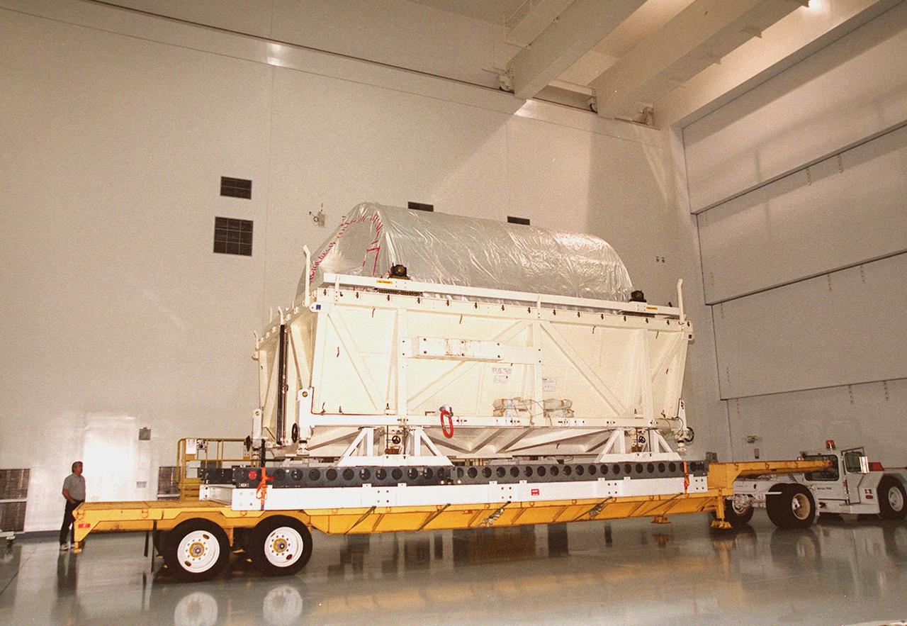 The lid is off the shipping container with the Multi-Purpose Logistics Module Donatello inside. It sits on a transporter inside the Space Station Processing Facility. In the SSPF, Donatello will undergo processing by the payload test team, including integrated electrical tests with other Station elements in the SSPF, leak tests, electrical and software compatibility tests with the Space Shuttle (using the Cargo Integrated Test equipment) and an Interface Verification Test once the module is installed in the Space Shuttle’s payload bay at the launch pad. The most significant mechanical task to be performed on Donatello in the SSPF is the installation and outfitting of the racks for carrying the various experiments and cargo. Donatello will be launched on mission STS-130, currently planned for September 2004