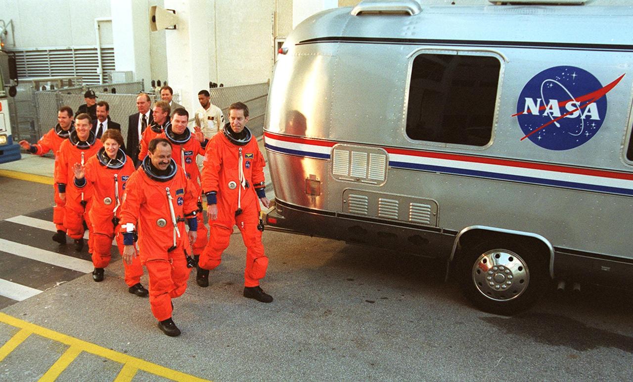 The STS-102 crew heads to the silver Astrovan after leaving the Operations and Checkout Building. In front are Mission Specialist Yury Usachev (left) and Commander James Wetherbee; second are Mission Specialist Susan Helms and Pilot James Kelly; third, Mission Specialists James Voss and Andrew Thomas; and last, Mission Specialist Paul Richards. Voss, Helms and Usachev are the Expedition Two crew, going to the International Space Station for their four-month rotation. The Astrovan will take the crew to Launch Pad 39B for a simulated countdown, part of Terminal Countdown Demonstration Test activities. STS-102 is the eighth construction flight to the Space Station, with Space Shuttle Discovery carrying the Multi-Purpose Logistics Module Leonardo. In addition, Expedition One will return to Earth with Discovery. Launch on mission STS-102 is scheduled for March 8